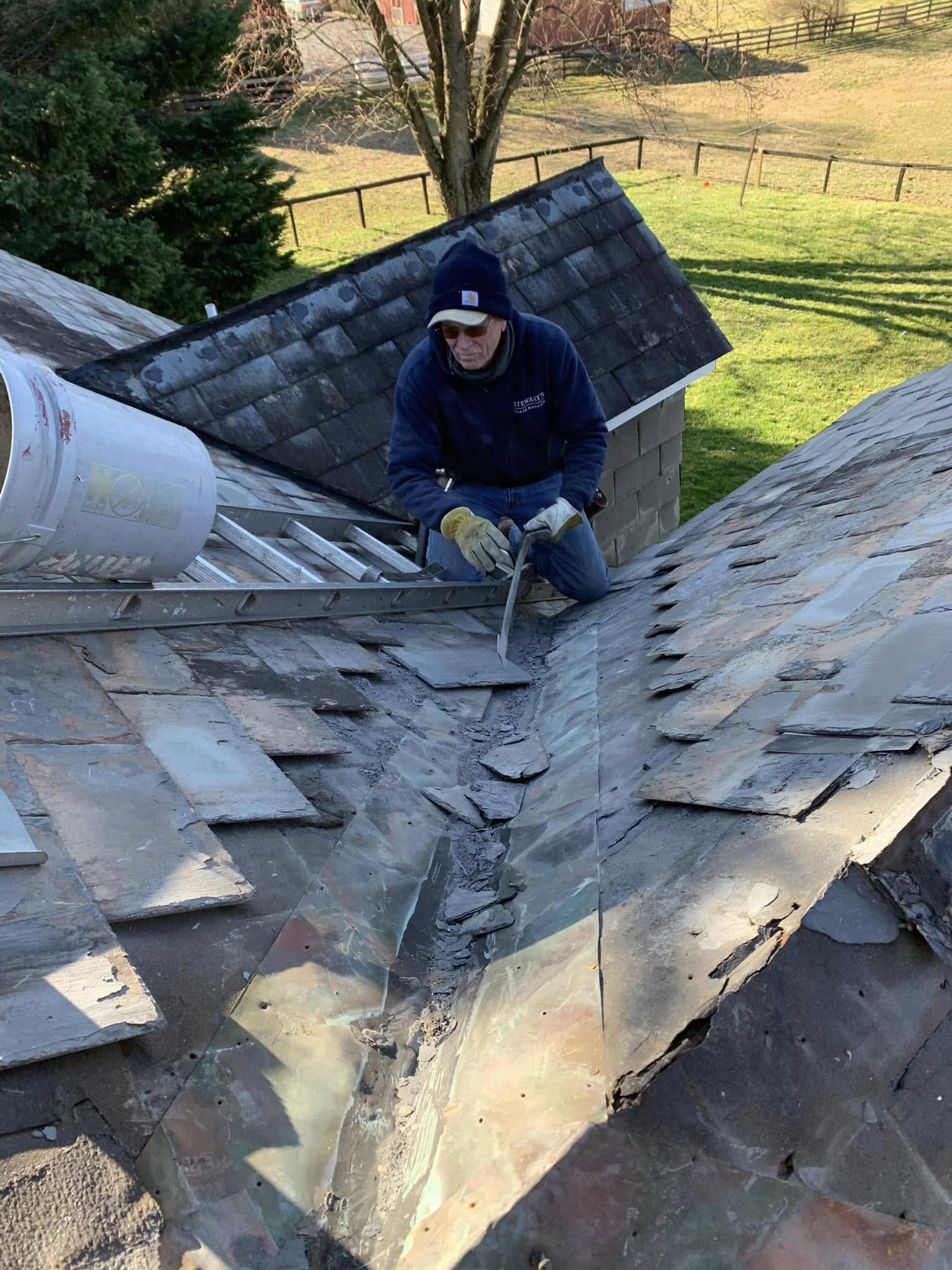 A man is working on the roof of a house.