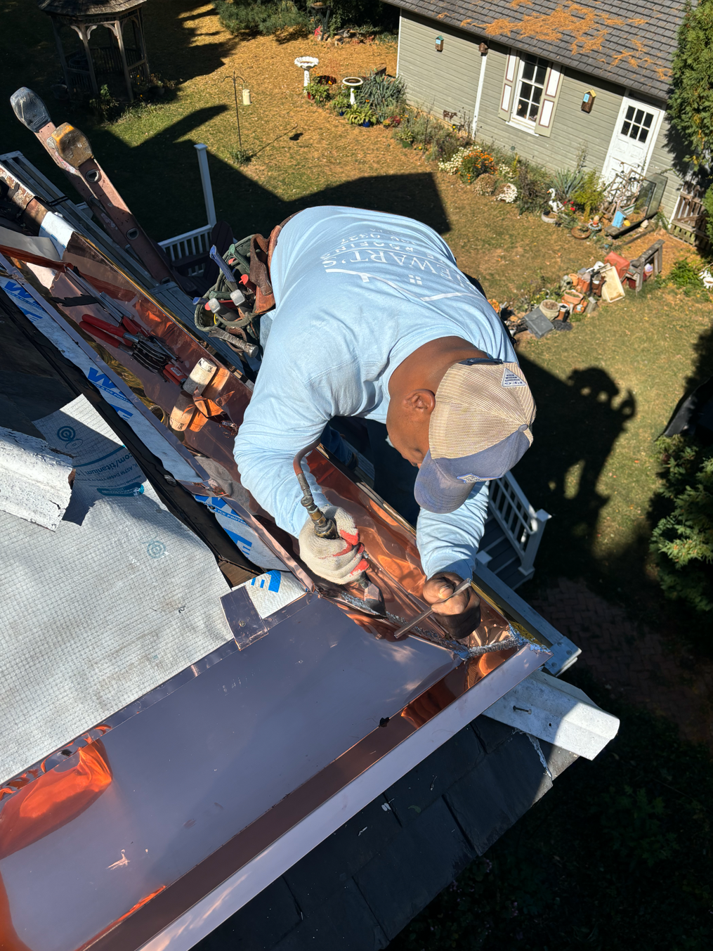 A man is working on the roof of a house.