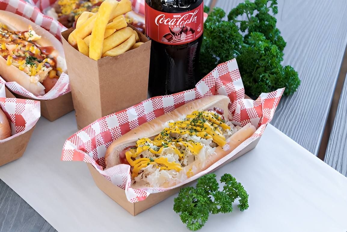 A Hot Dog And French Fries Are On A Table Next To A Coca Cola Bottle — Noosaville Fish Market In Tewantin, QLD