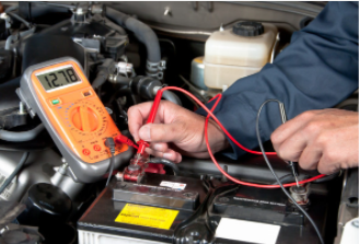 Automobile mechanic in Cheyenne checking cars battery.