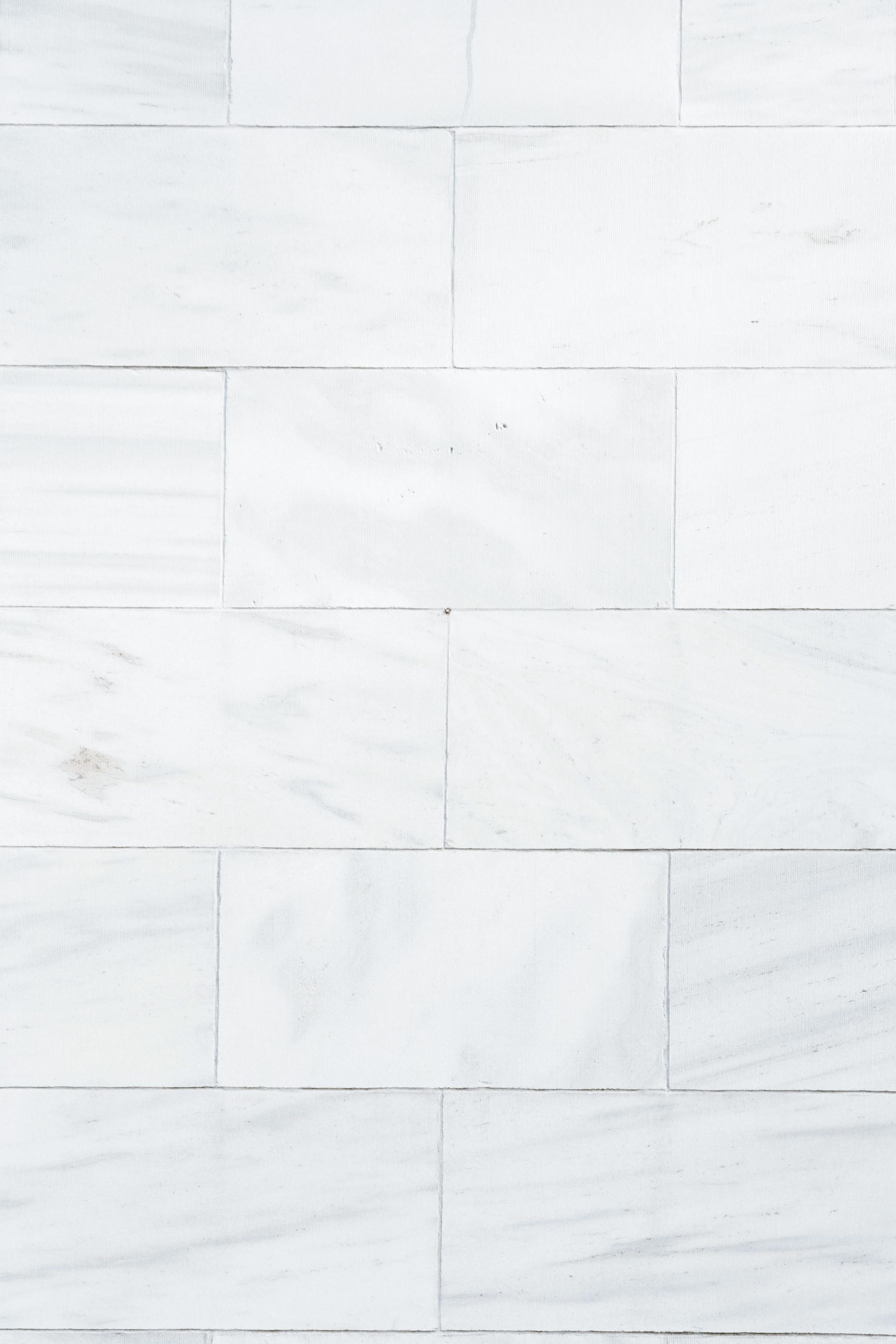 A close up of a white tile wall.