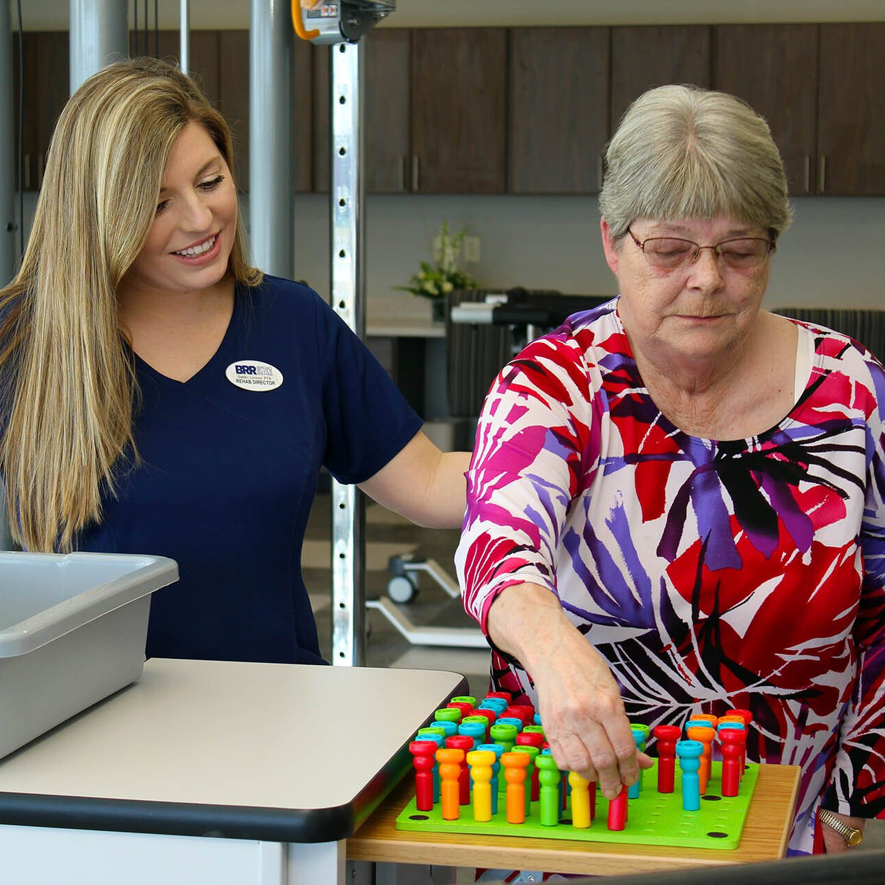 A nurse is helping an elderly woman play a game