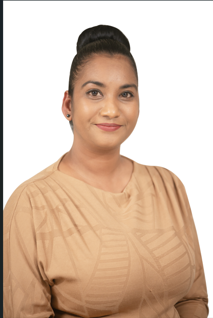 A woman with her hair in a bun is smiling for the camera