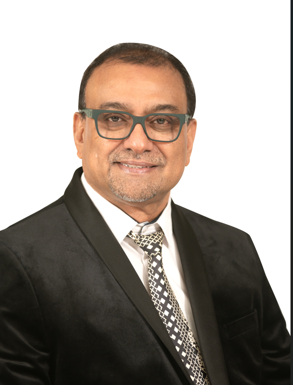 A man in a suit and tie is smiling for the camera