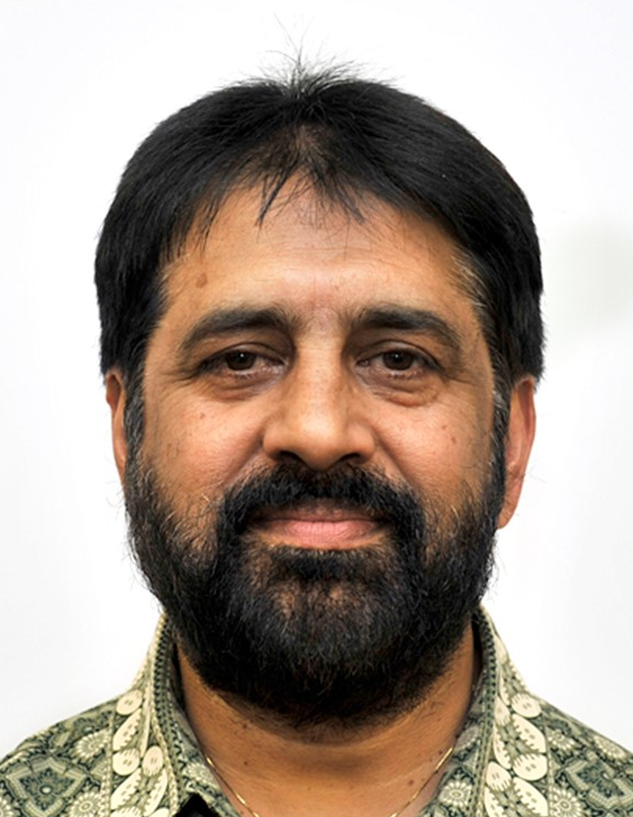 A man with a beard and a green shirt is smiling for the camera.