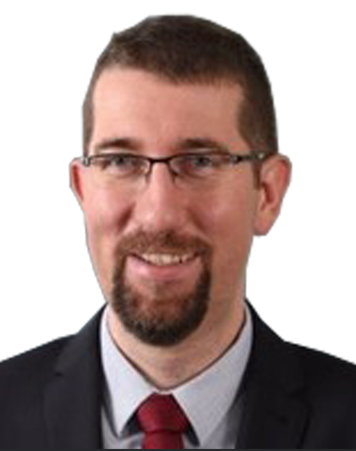 A man with glasses and a beard is wearing a suit and tie.