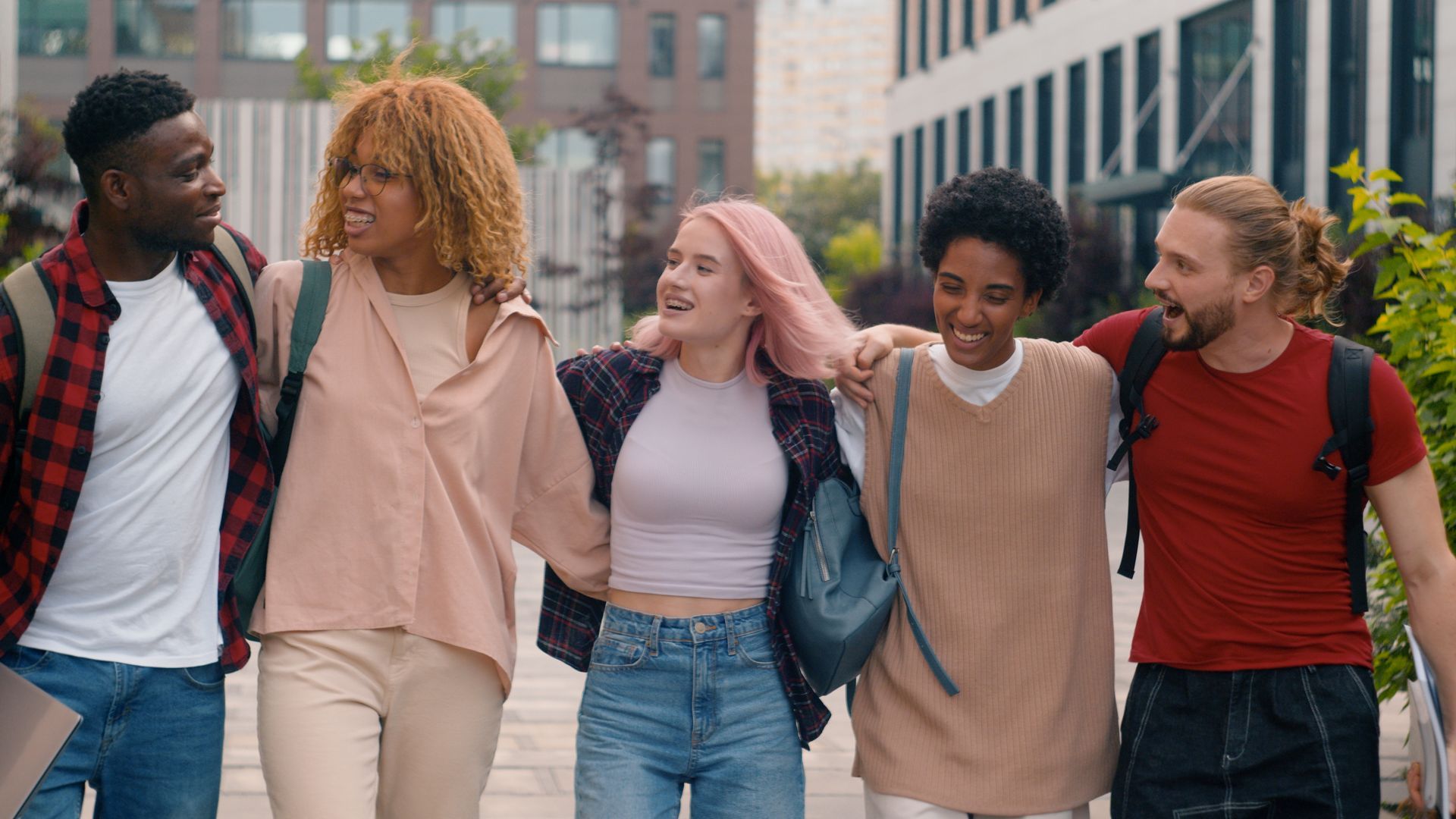 A group of young people are walking down a sidewalk.