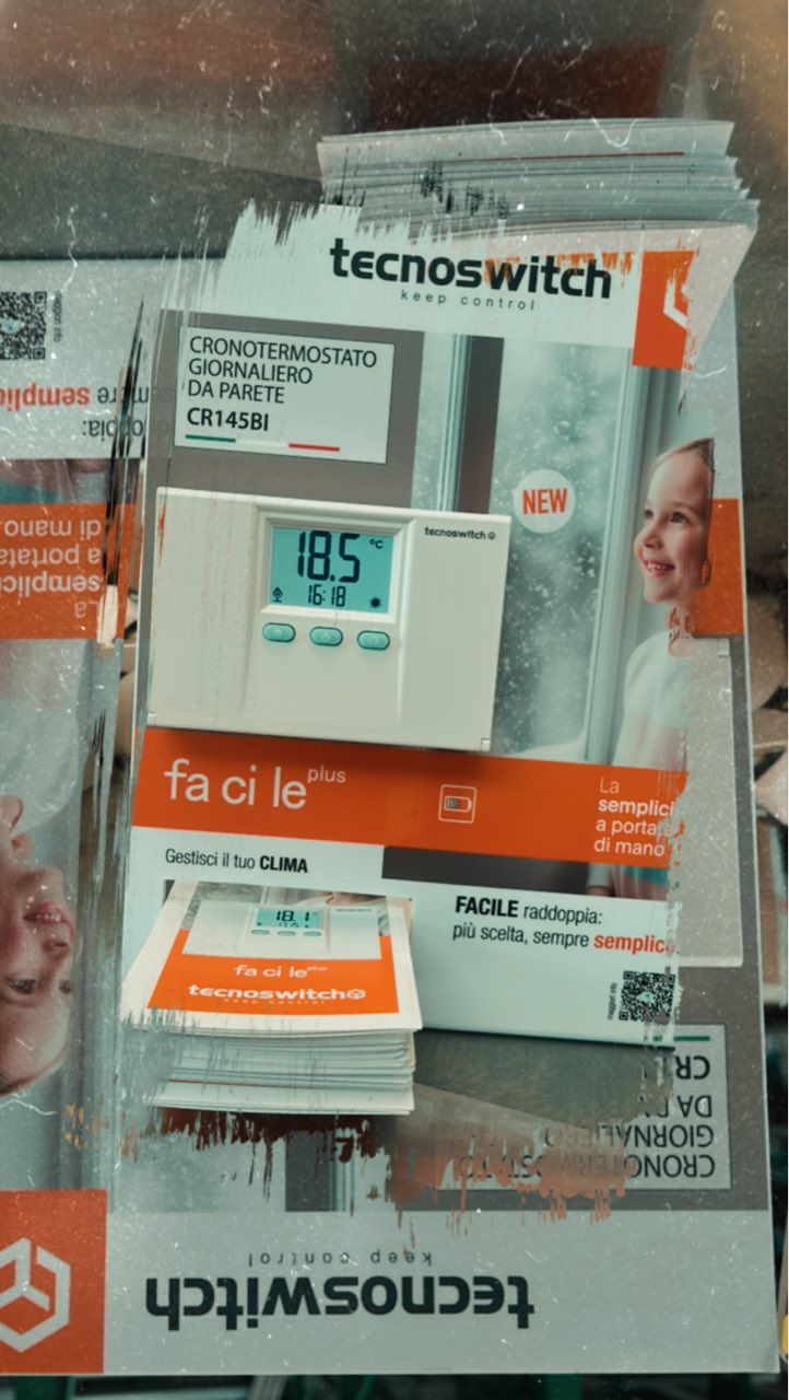 Display del termostato Tecnoswitch con una persona sorridente che mostra una temperatura di 18,5 gradi.