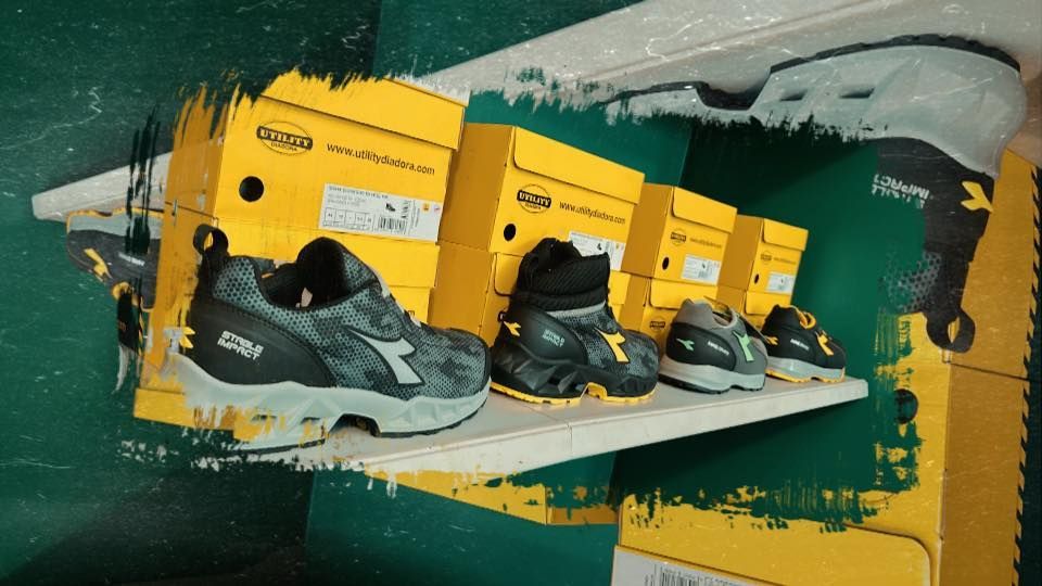 Scarpe e scatole di stivali da lavoro su uno scaffale, in un negozio.