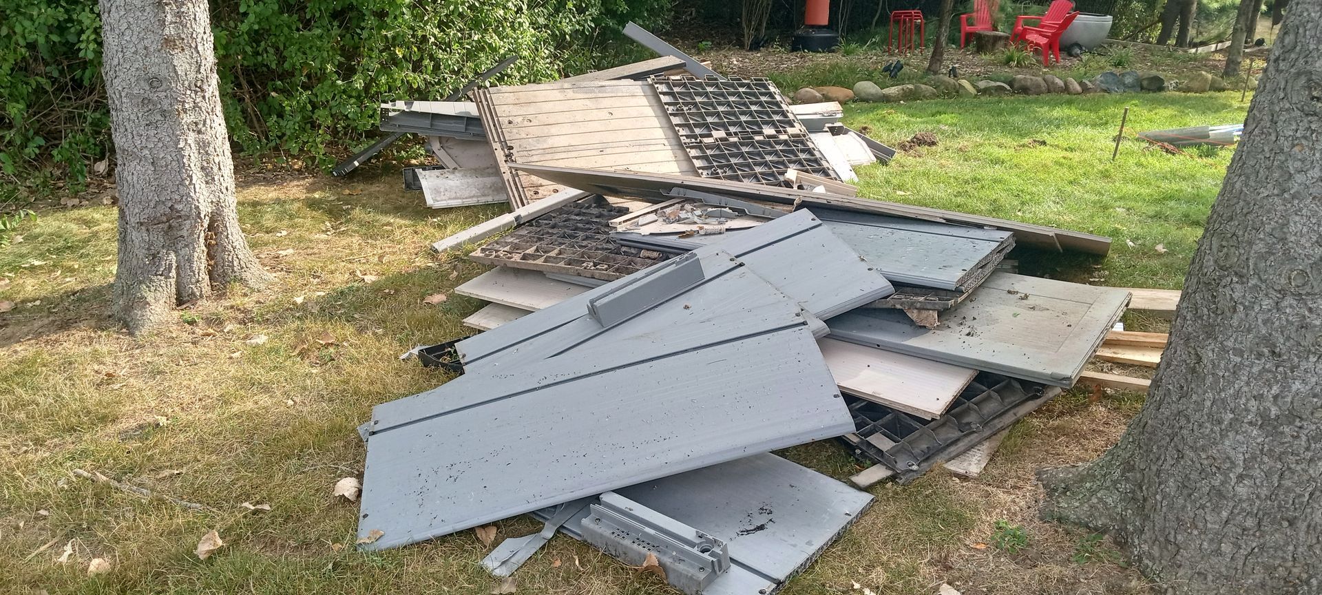 A pile of pieces of metal sitting on top of a lush green field.