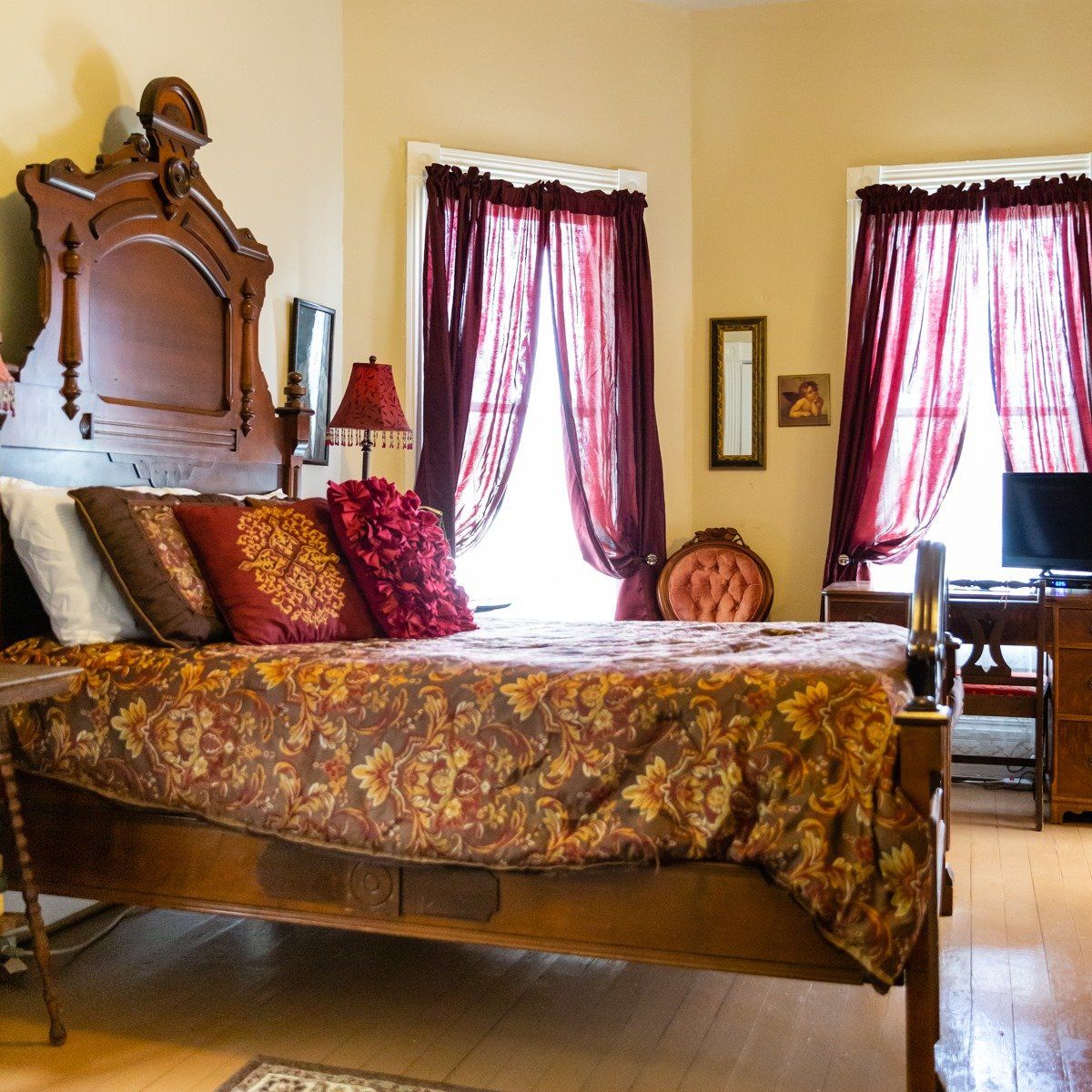 A bedroom with a bed a desk and a television