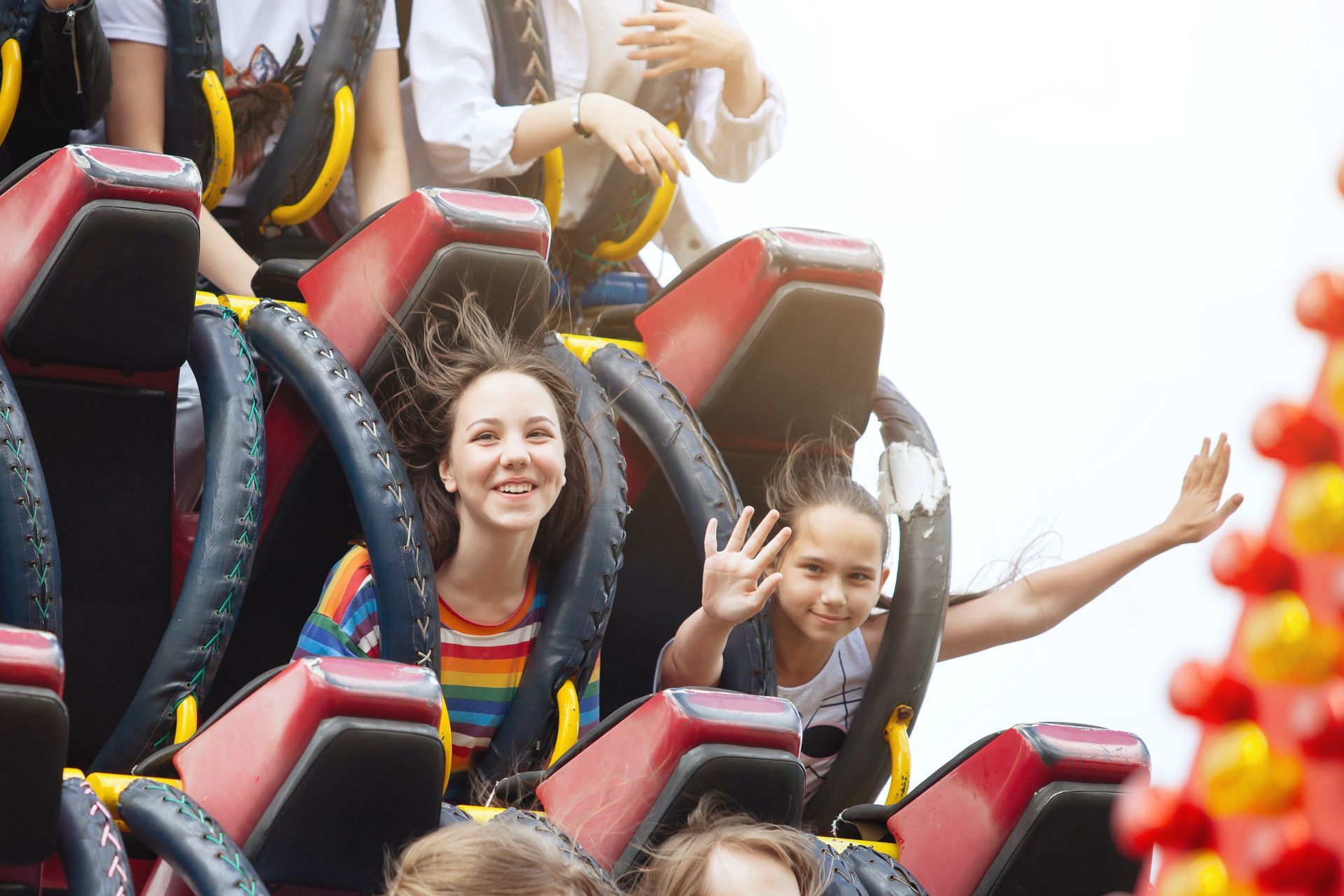 A group of people are riding a roller coaster at an amusement park.