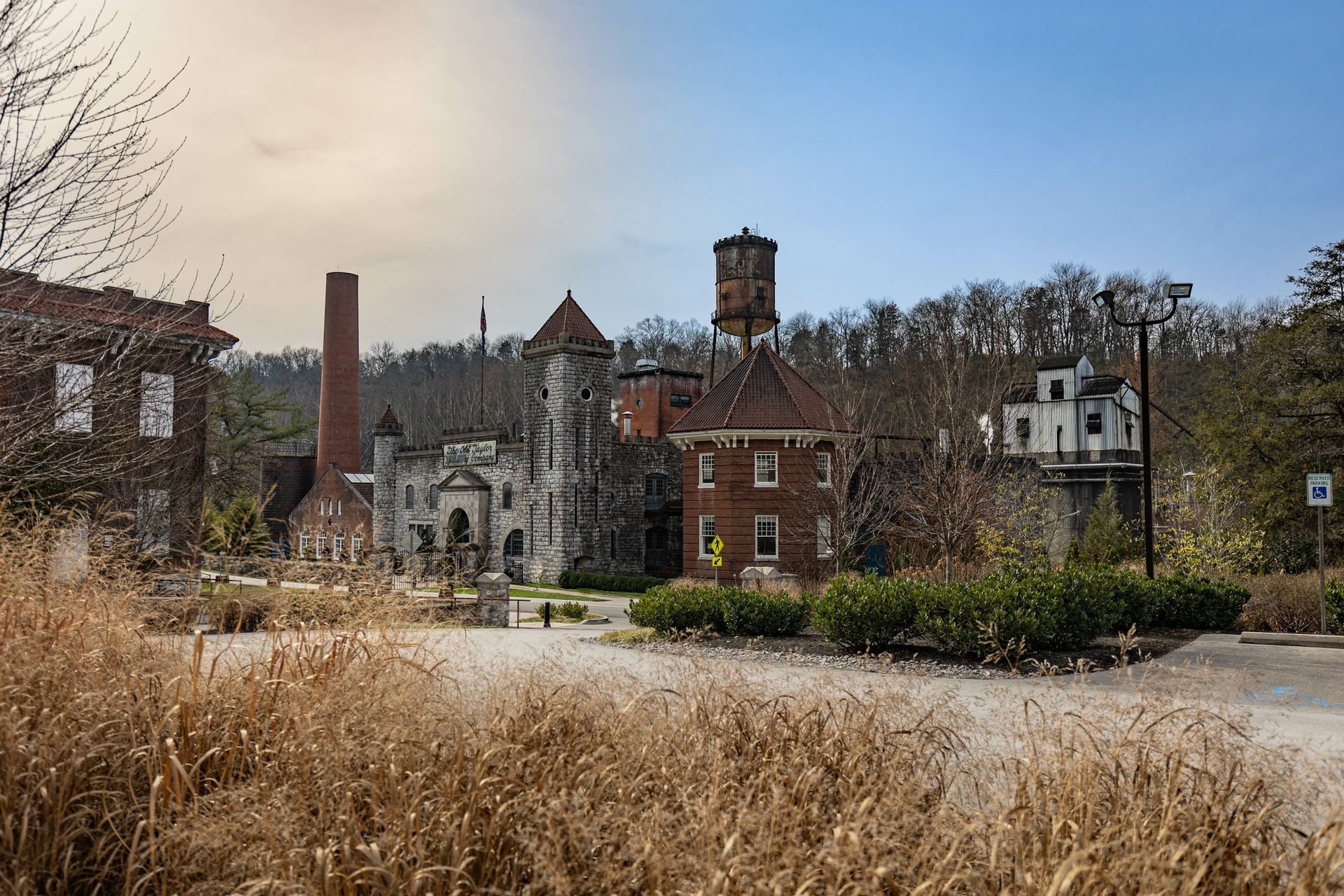 A brick building with a water tower in the middle of a field.