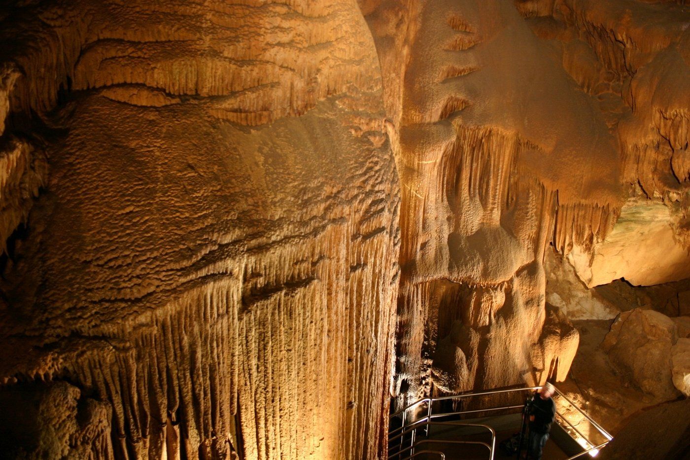 A person is standing in a cave with a staircase.