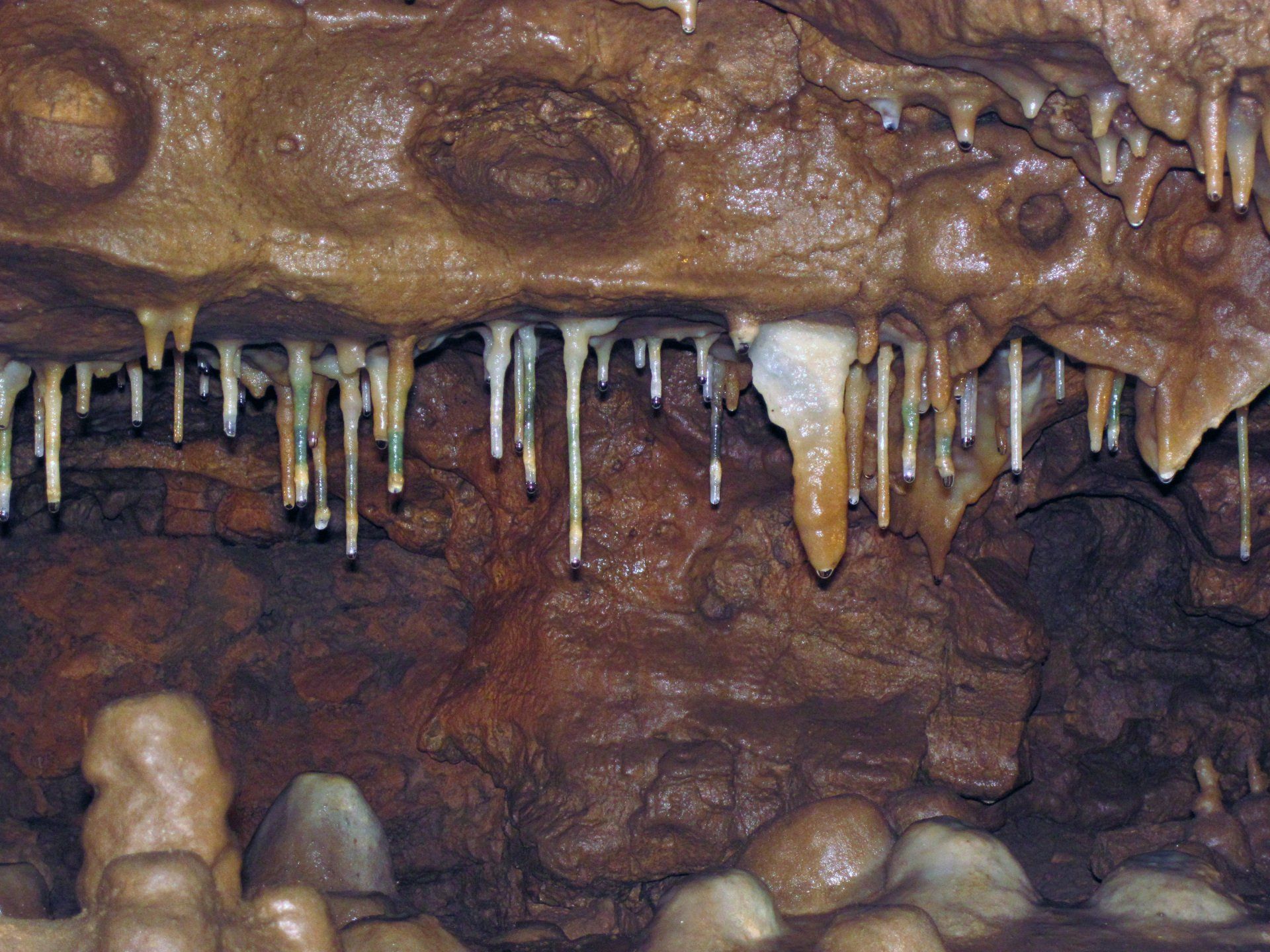 A cave with a lot of icicles hanging from the ceiling