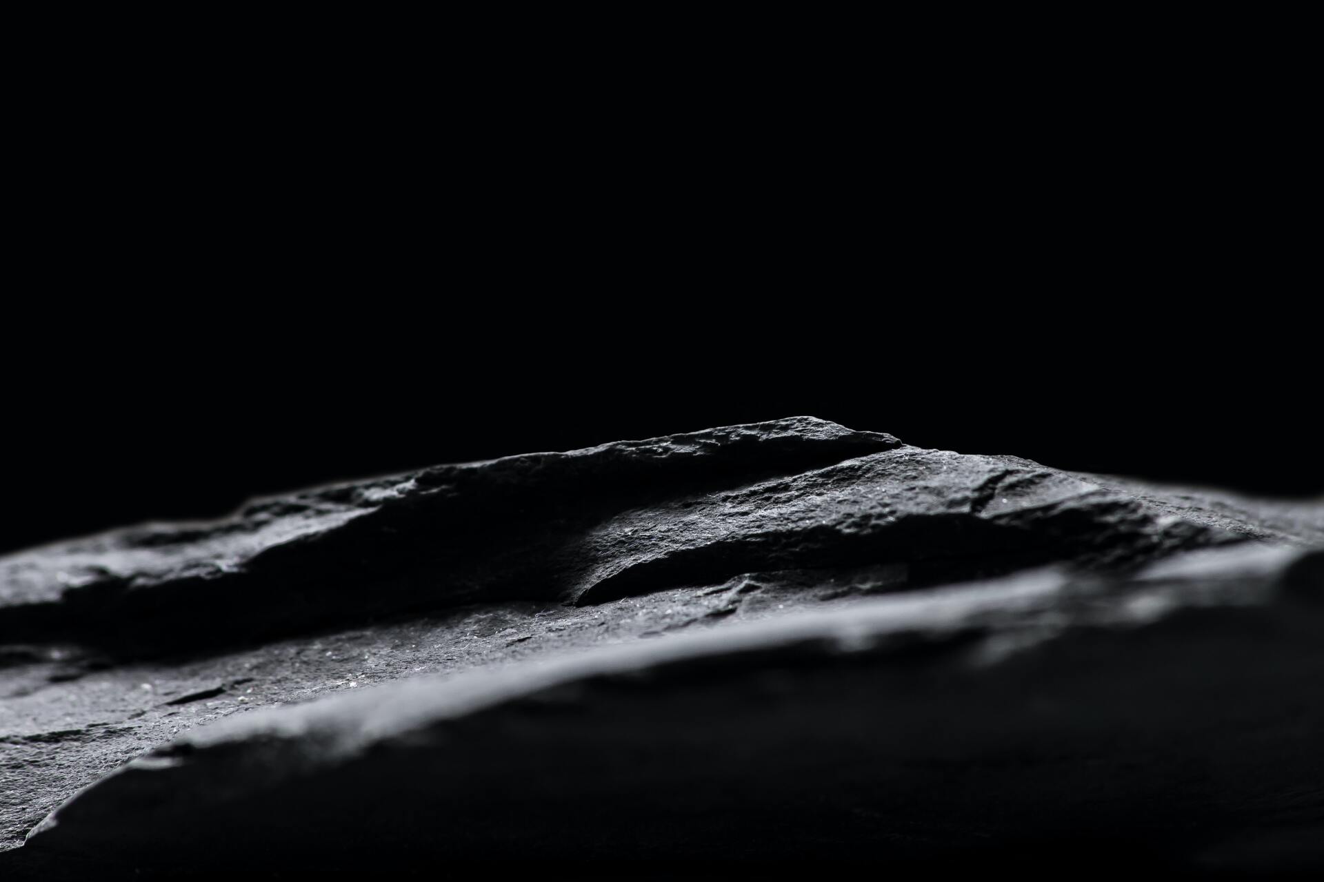 A black and white photo of a rock on a black background.