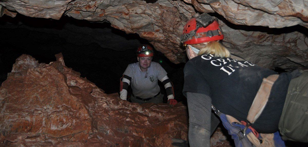 A man and a woman are standing in a cave.
