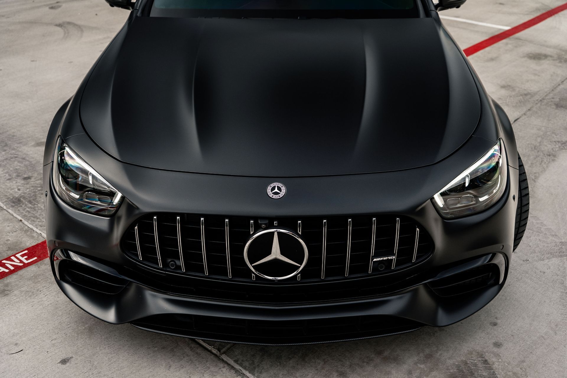 Front view of a matte black Mercedes sports car parked in a garage