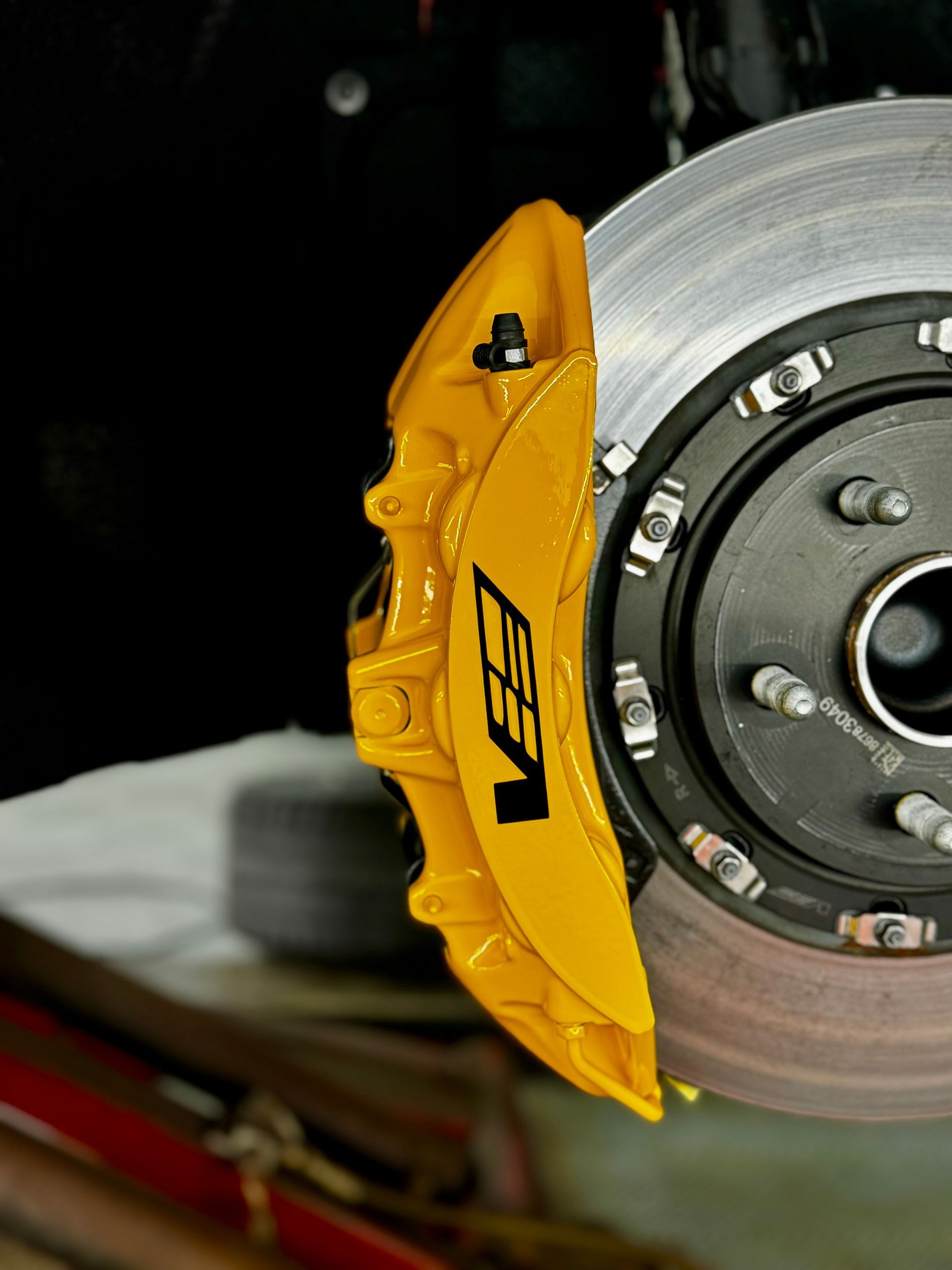 Close-up of a yellow VET brake caliper and silver disc brake assembly on a vehicle