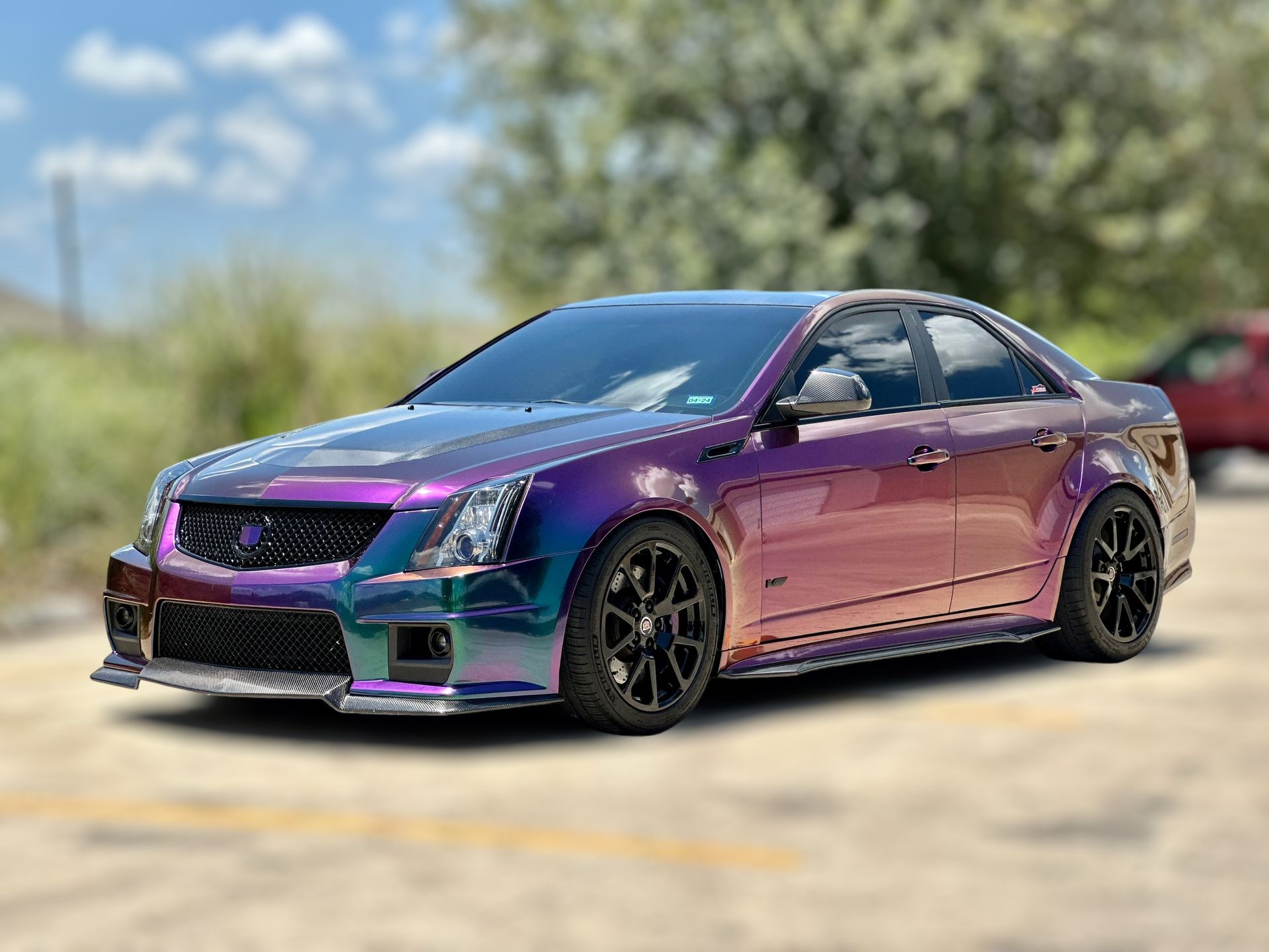 Purple sports sedan parked outdoors on a sunny day