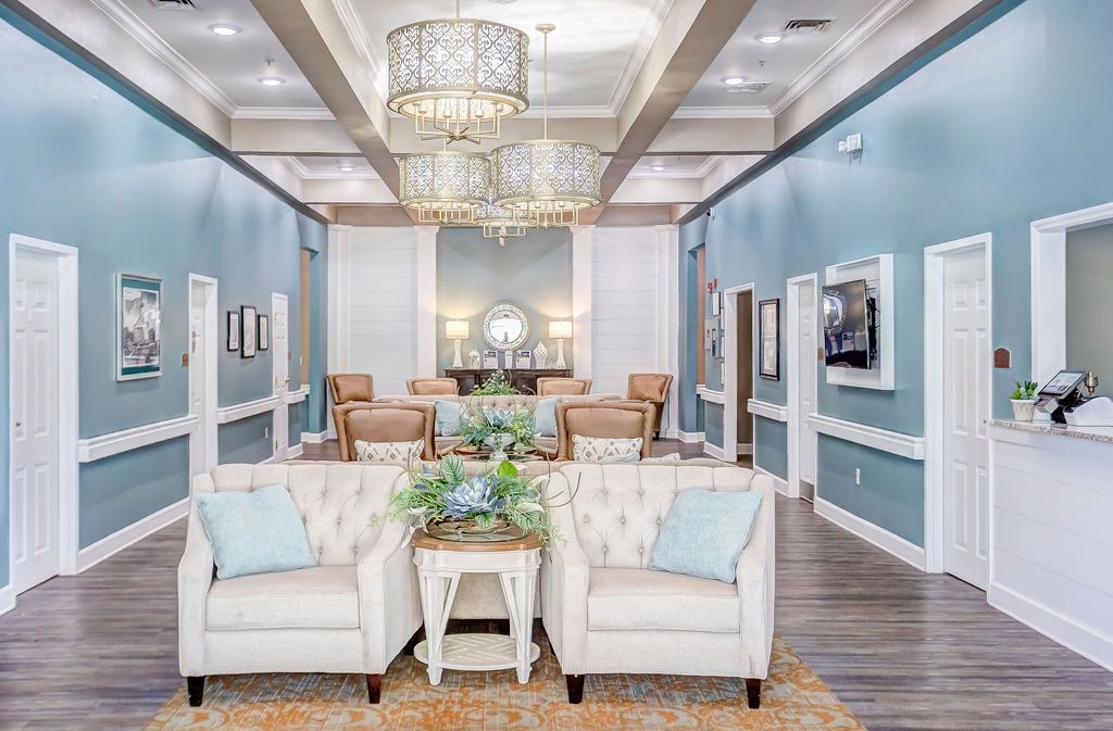 Bright living room with white sofas, chandelier, and blue walls in a stylish open interior.