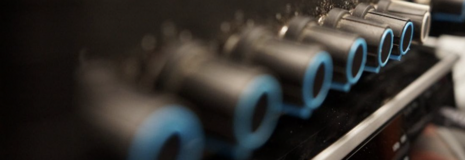 Close-up of a black machine with several cylindrical objects with blue rims.