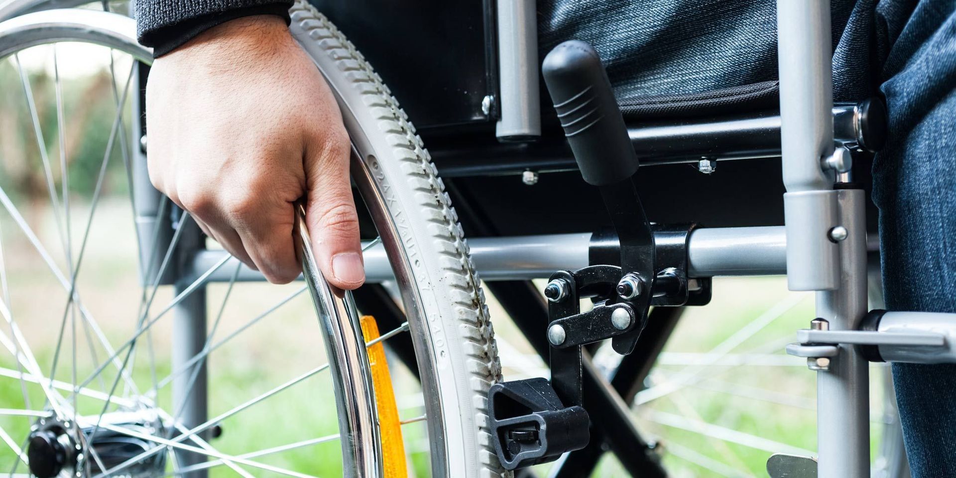 Man in wheelchair, petting a dog outdoors. Golden sunlight.