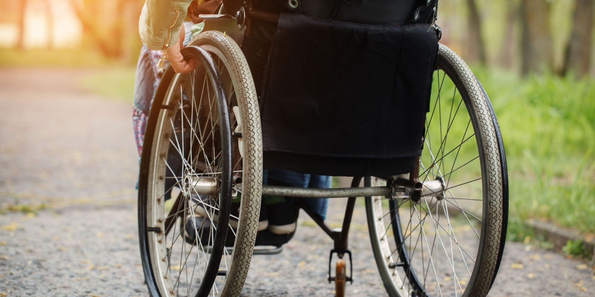 A person in a wheelchair is walking down a path.