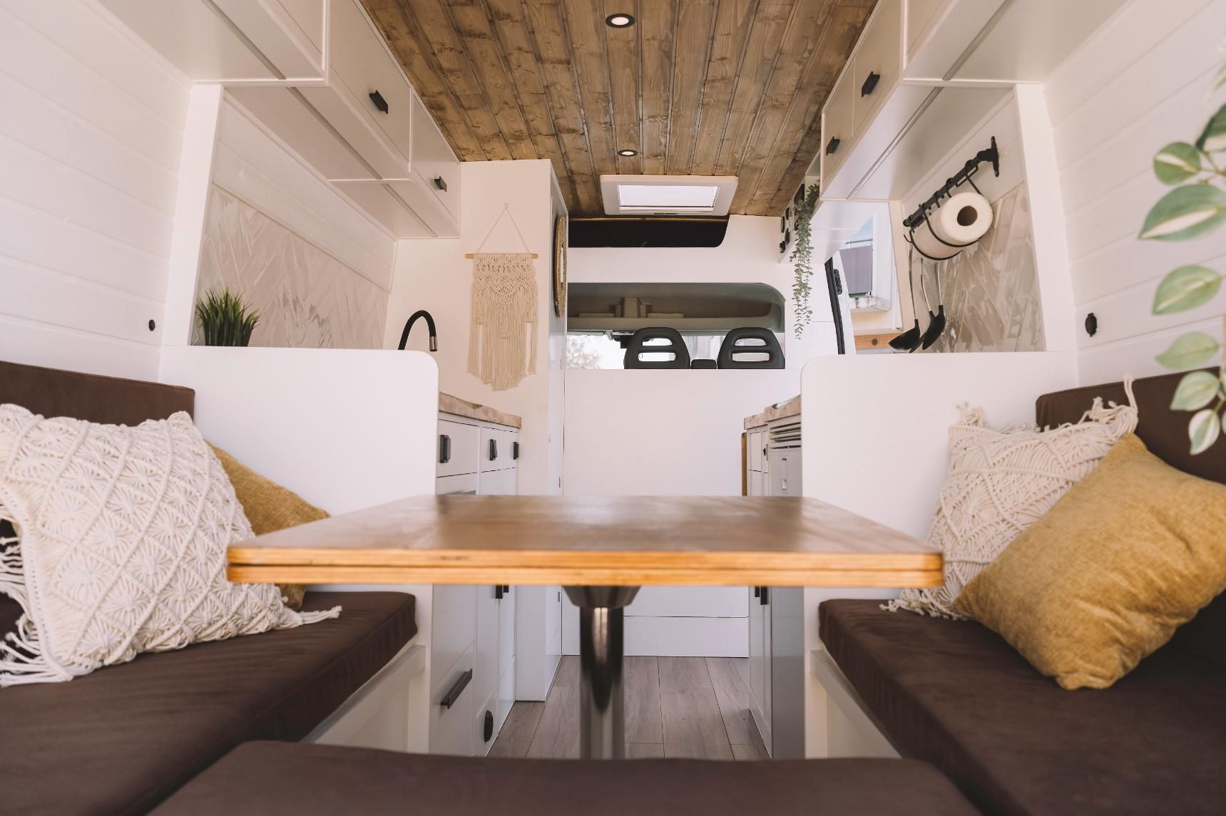 The Inside of a Camper Van With a Table and Couch — Lake Macquarie Caravan Repairs In Cardiff, NSW