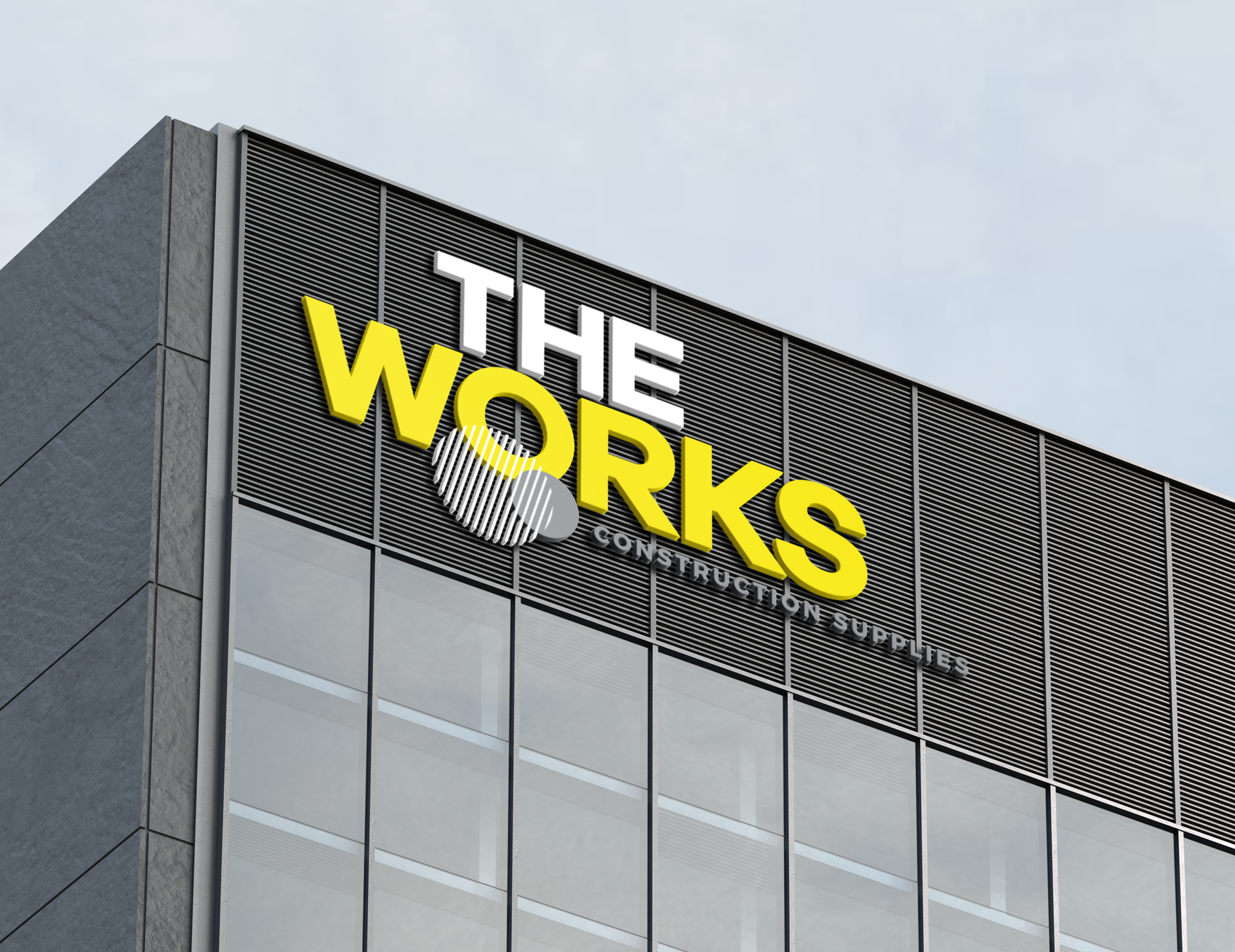Storefront sign reading “THE WORKS” in yellow and white letters on a modern building facade