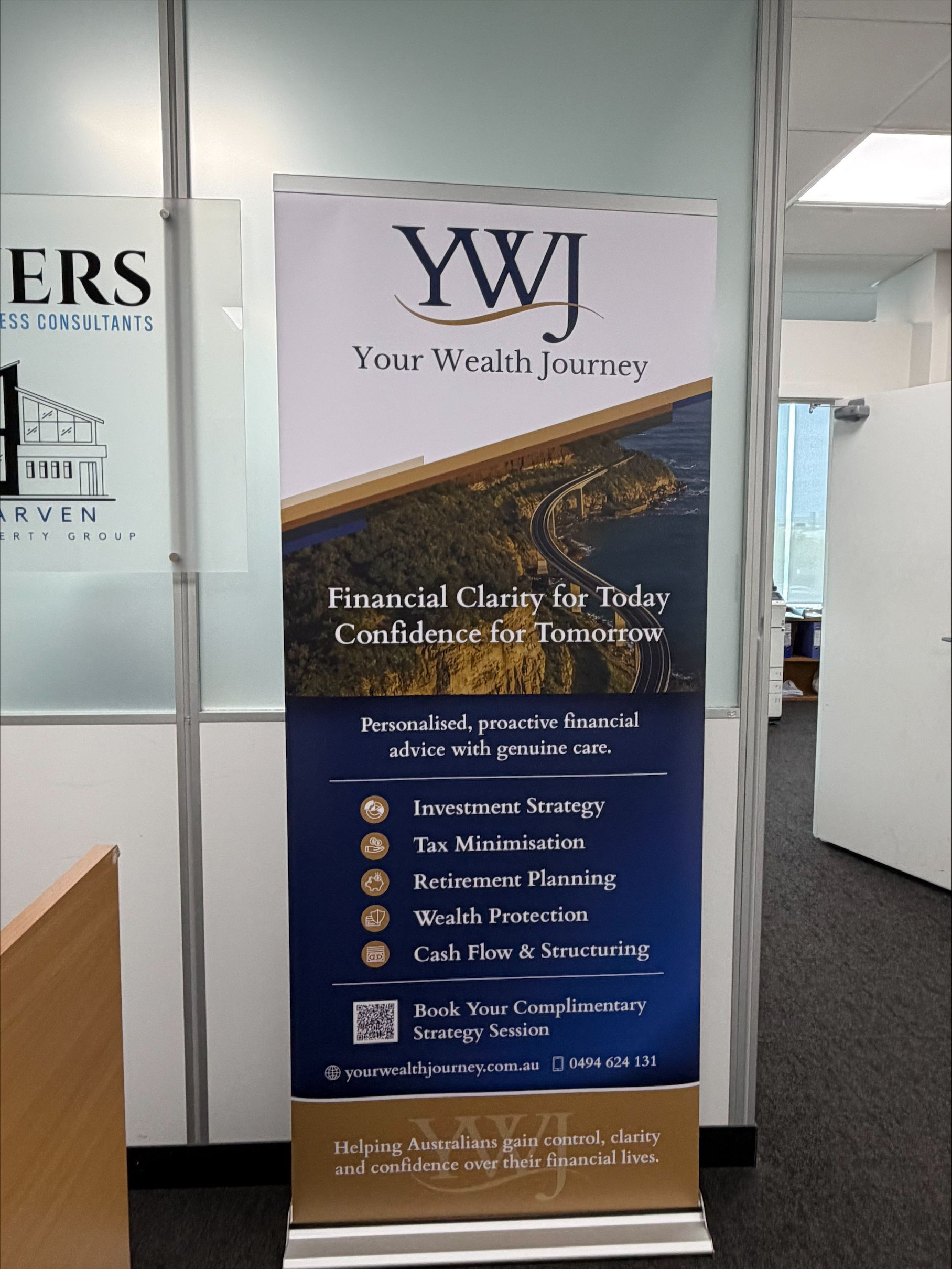 Vertical YWJ banner in an office hallway, blue and gold, advertising financial clinic services.