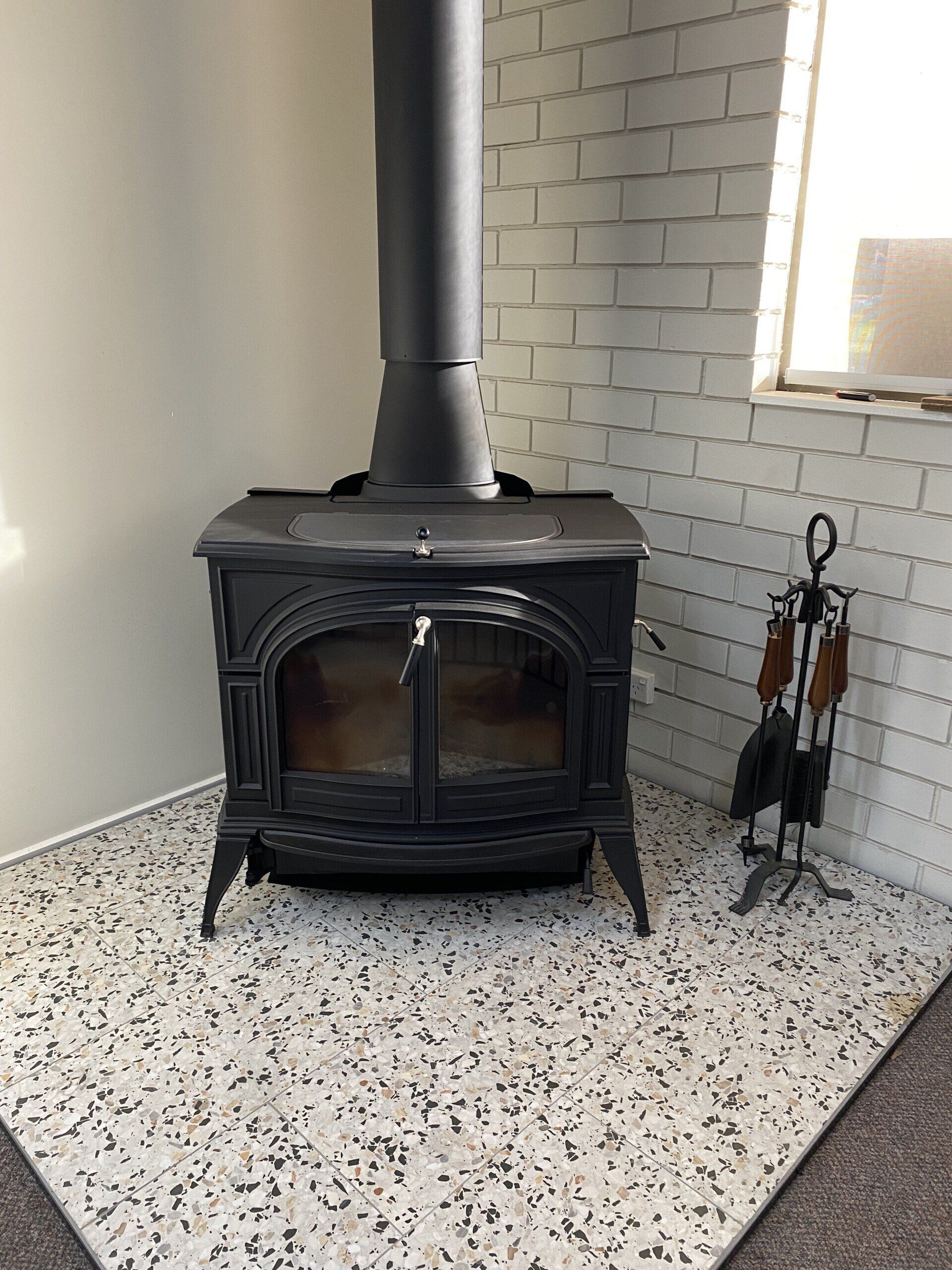 freestanding charcoal coloured fireplace in the corner of room
