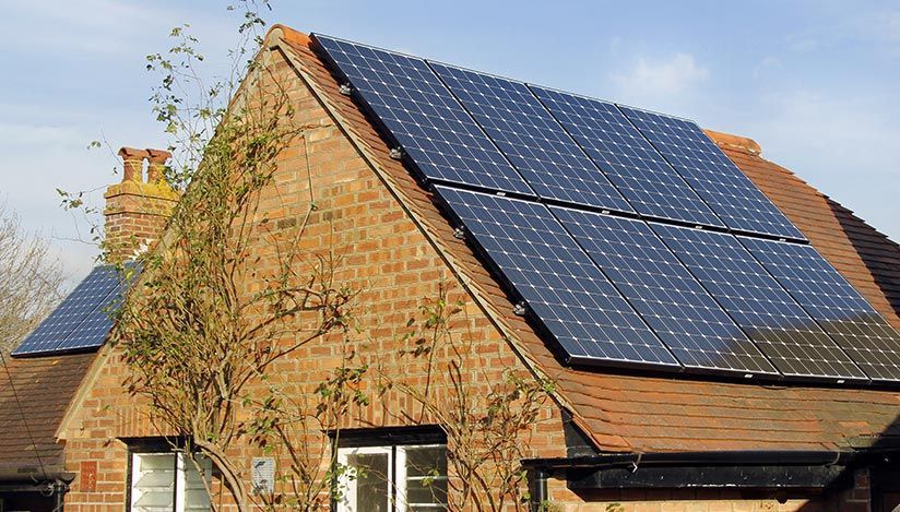 A brick house with solar panels on the roof.