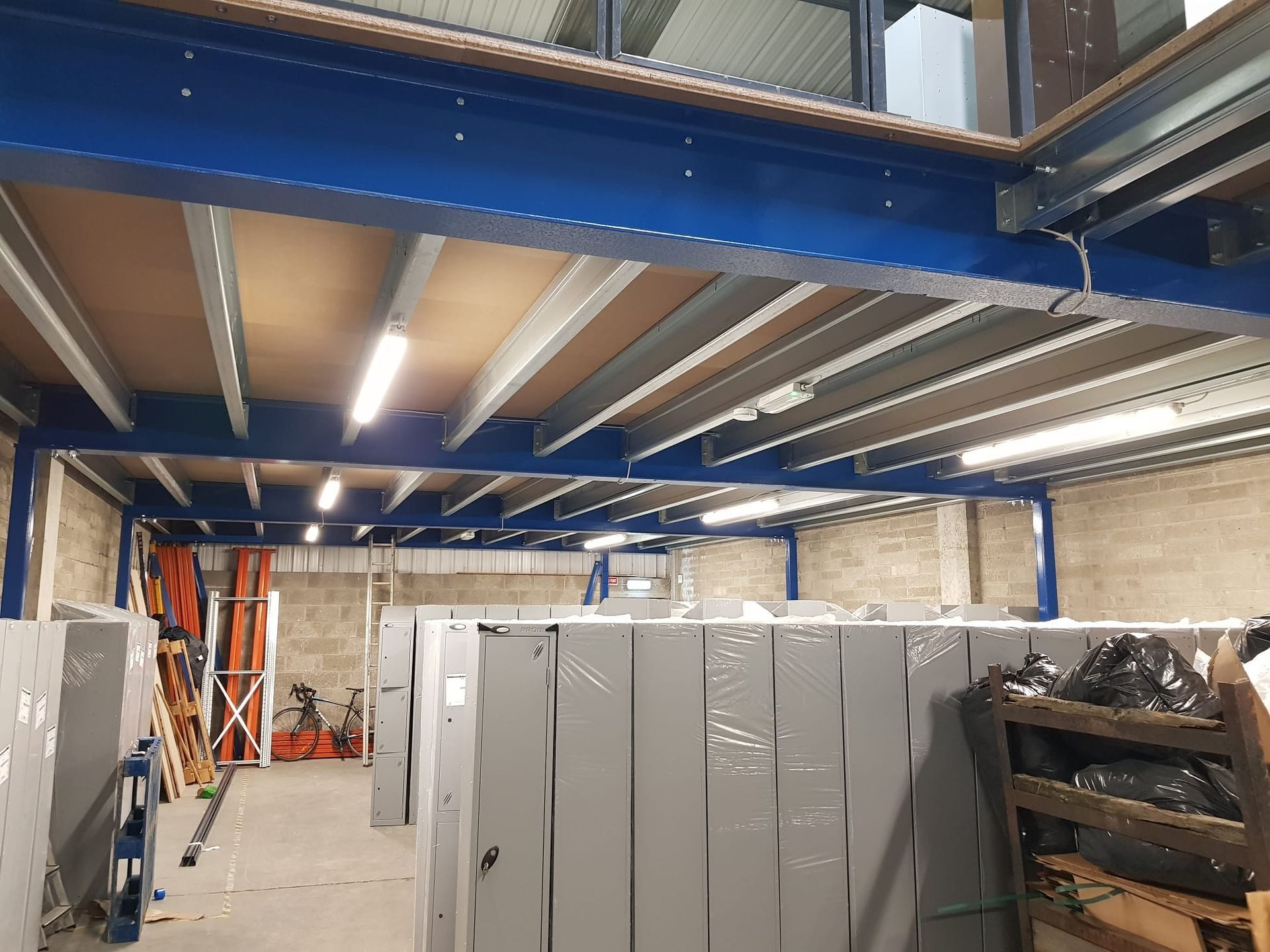 A large warehouse with a blue ceiling and a lot of shelves.