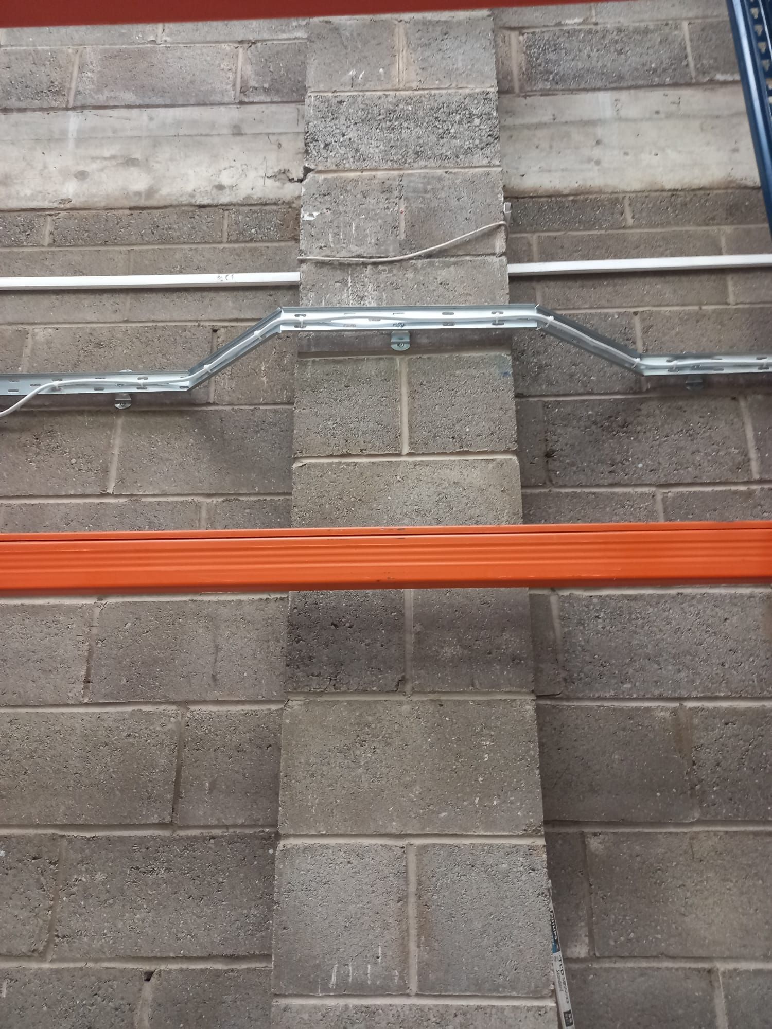 A brick wall with a metal pipe going through it