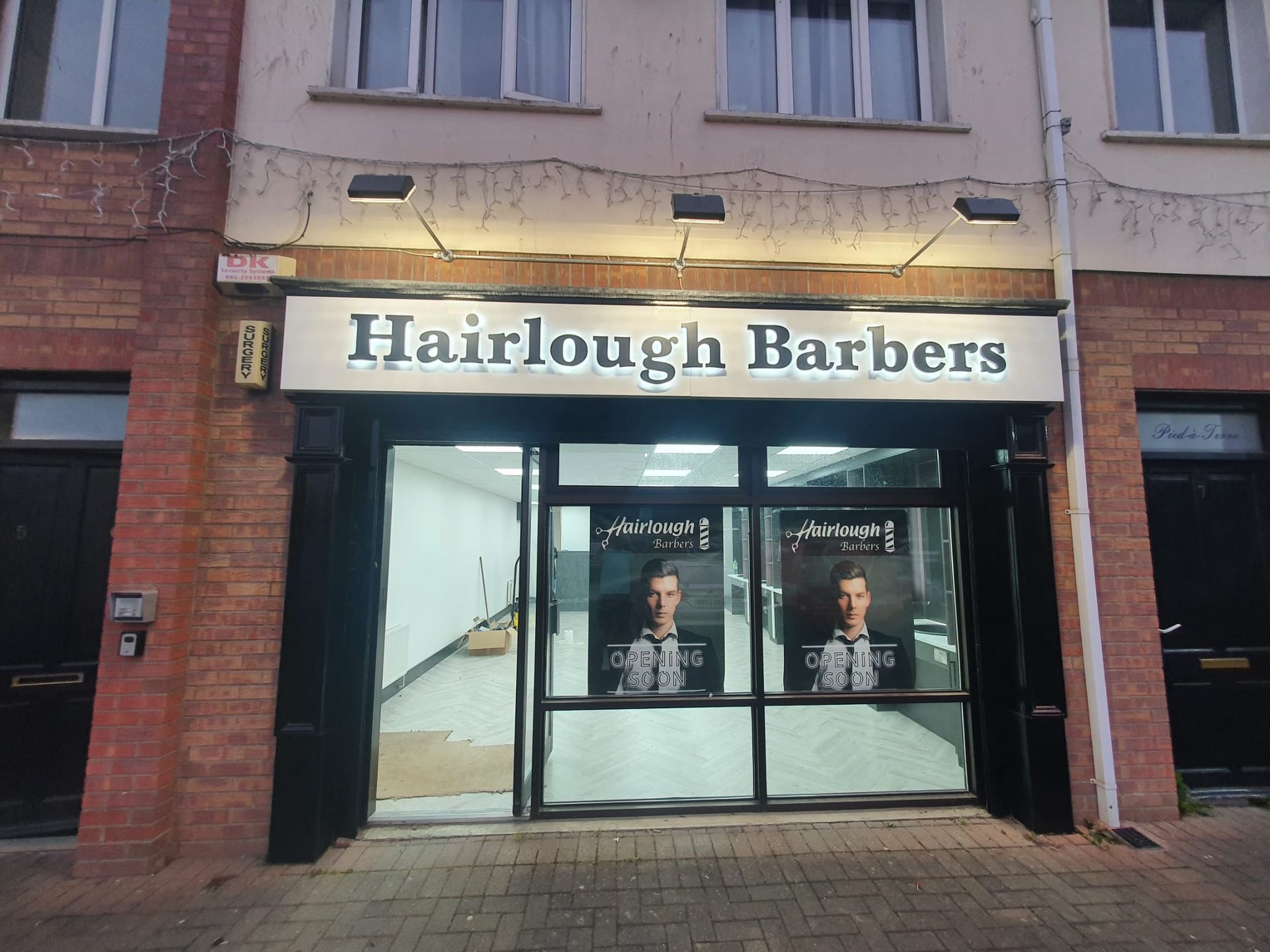 A brick building with a sign that says hairlough barbers