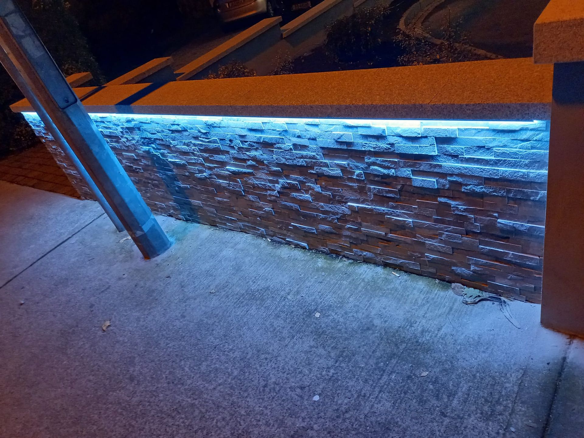A brick wall with blue lights on it at night