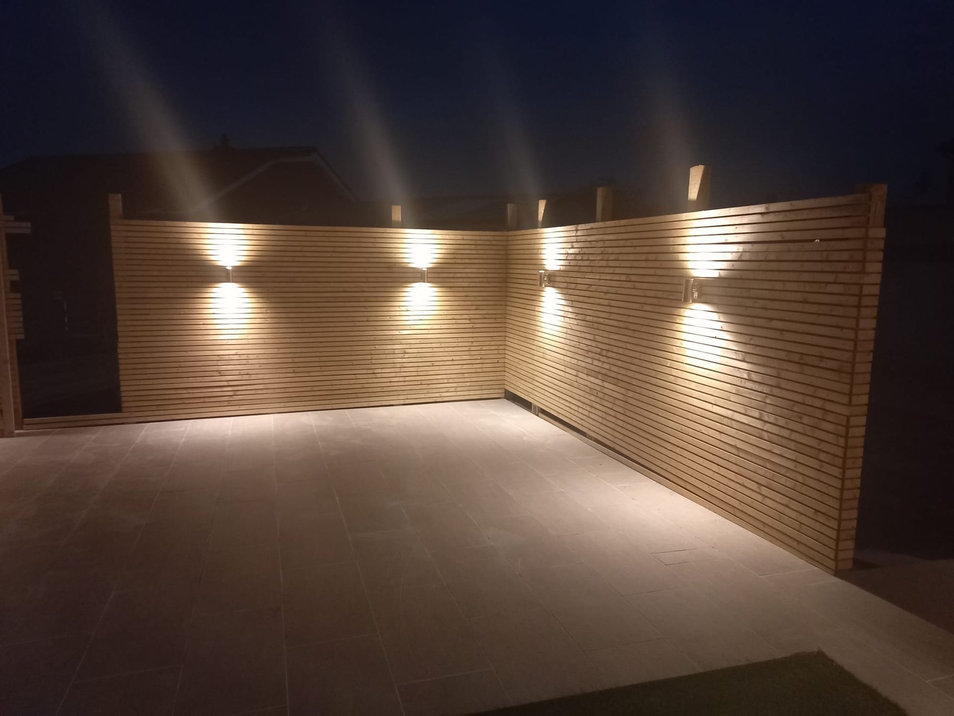 A wooden fence with lights on it at night