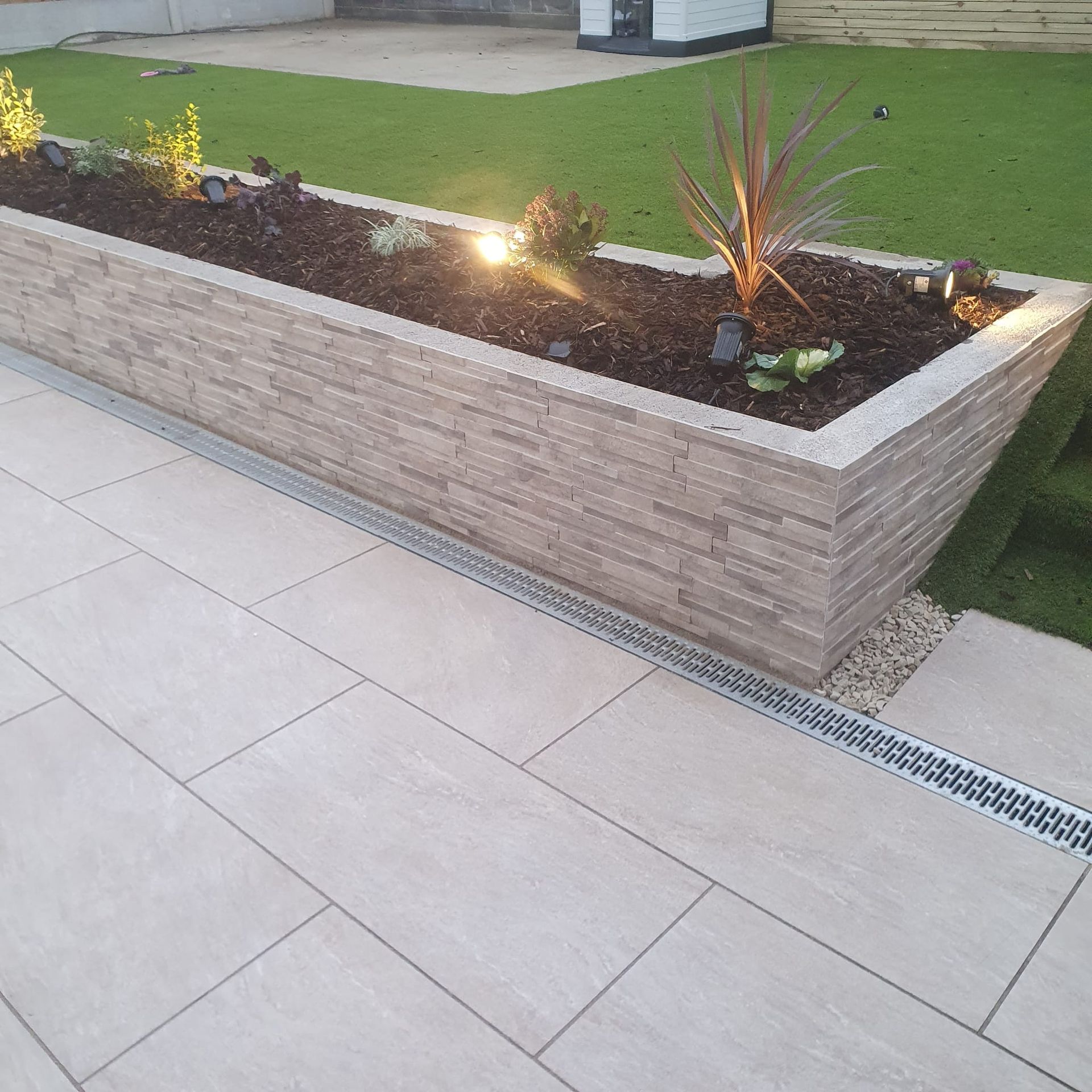A large brick planter with plants in it