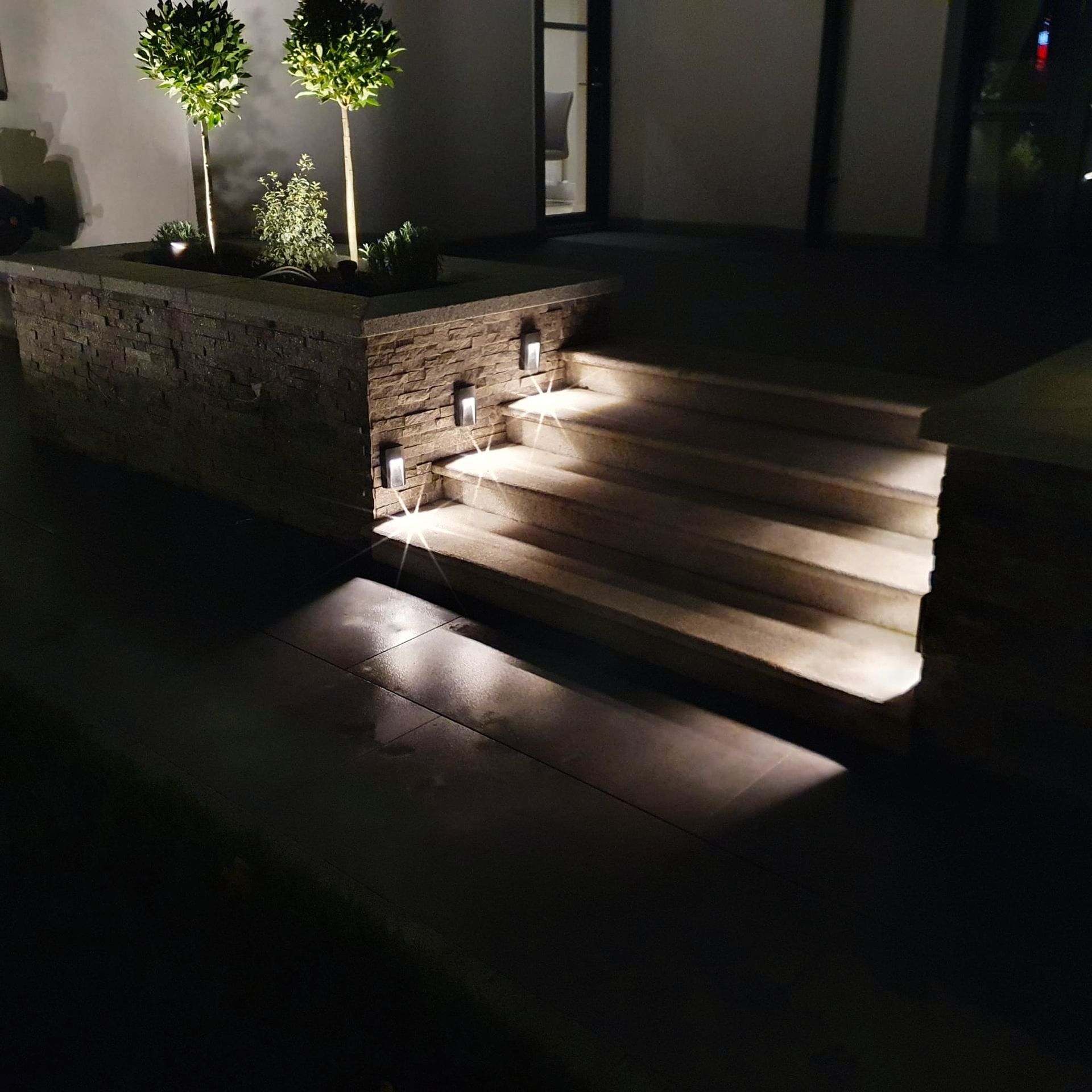 A set of stairs leading up to a house at night