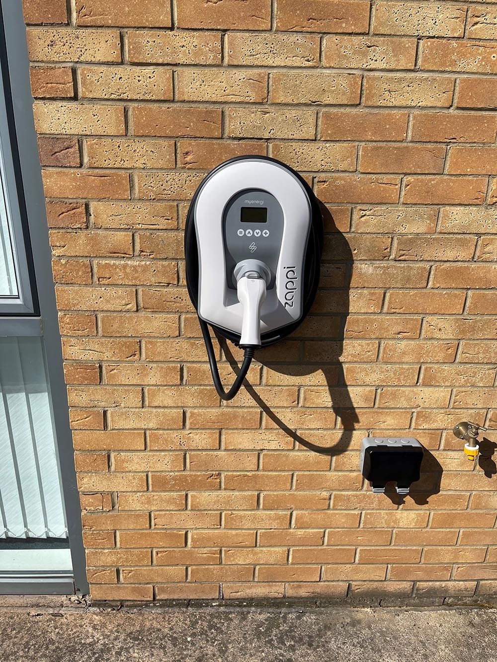 A brick wall with a charging station attached to it.