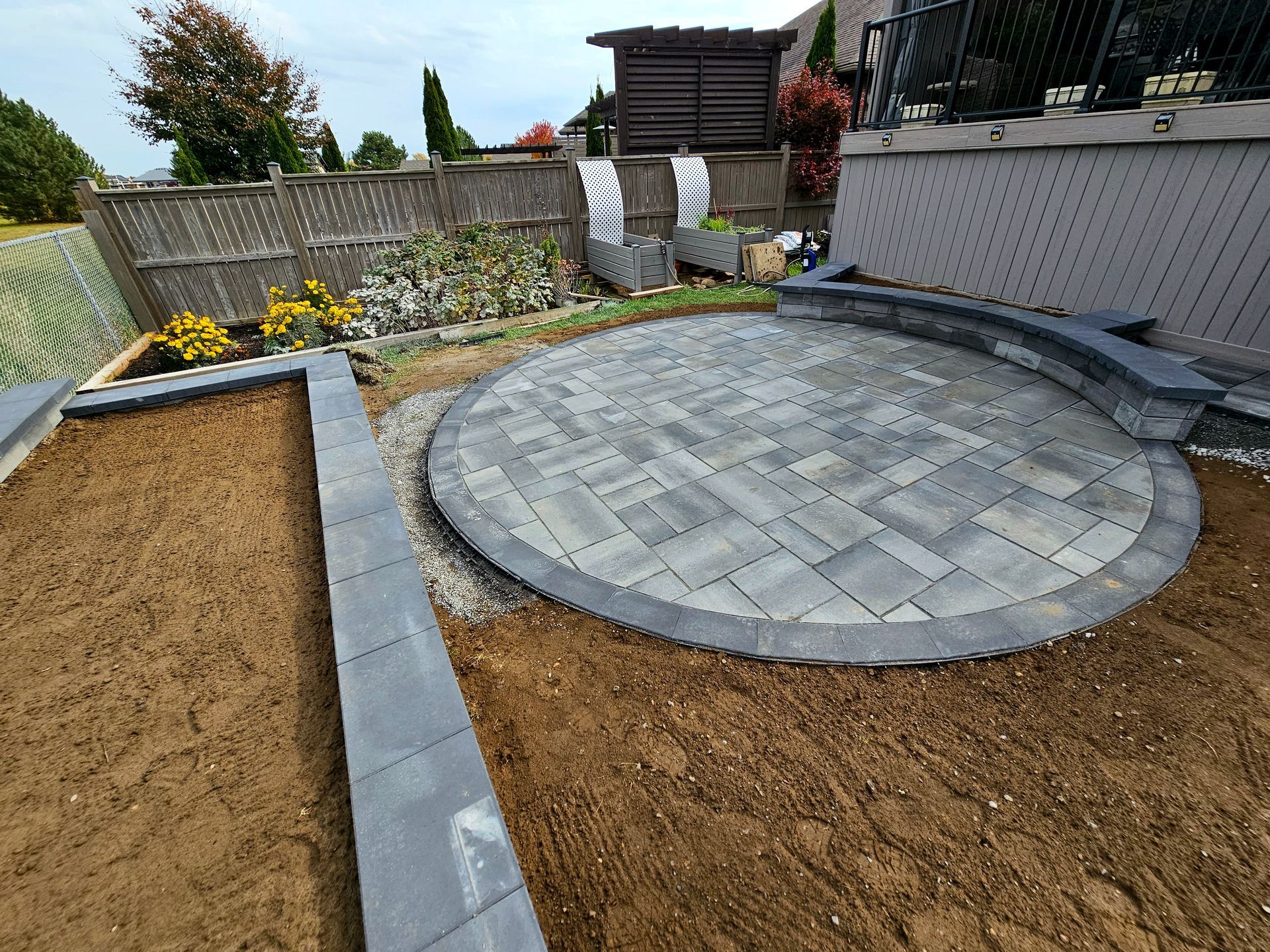 a circular patio is being built in a backyard .