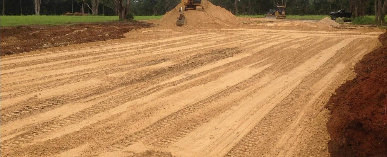 a large pile of dirt is sitting on top of a dirt road .