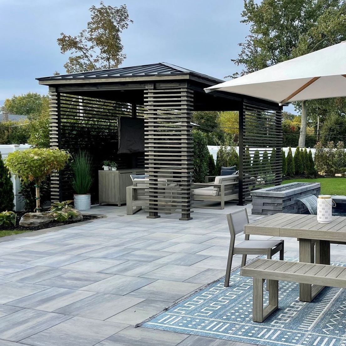 a pergola with chairs and a table underneath it