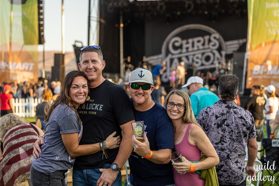 A group of people are posing for a picture at a concert.