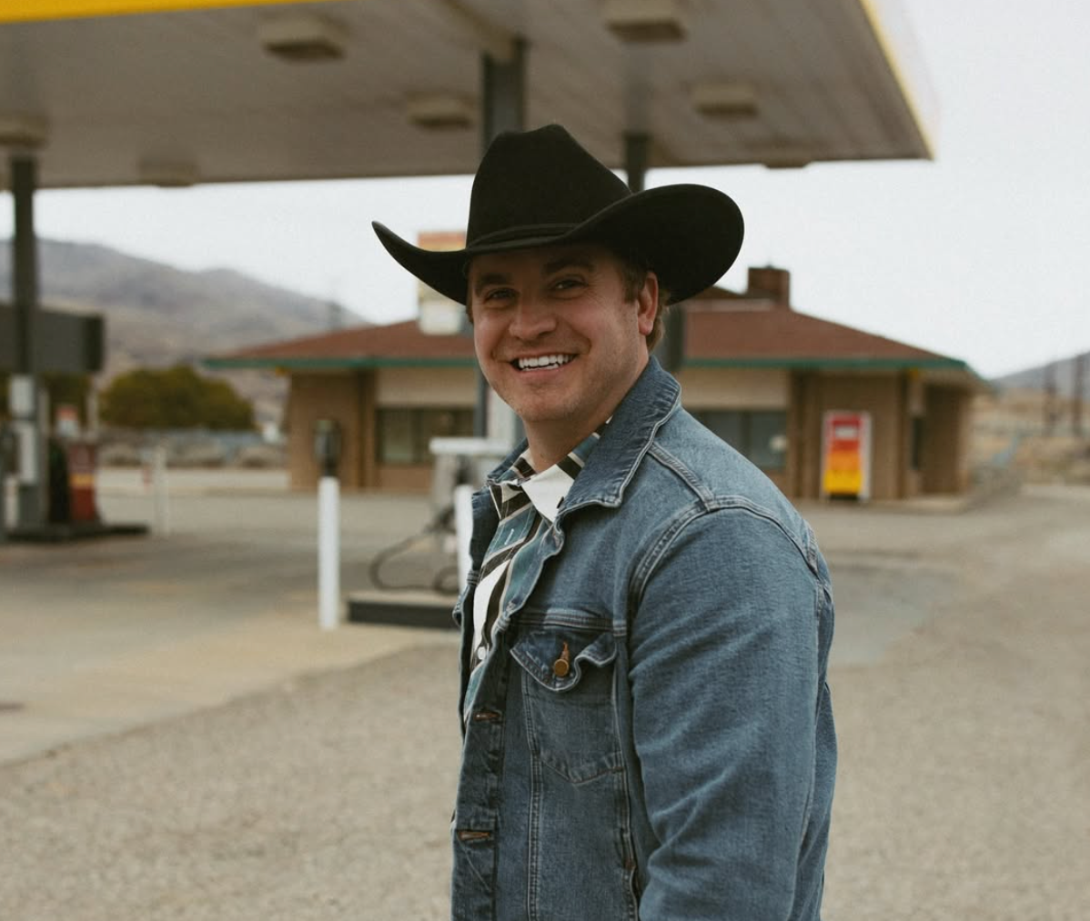 A man in a cowboy hat is playing an acoustic guitar.