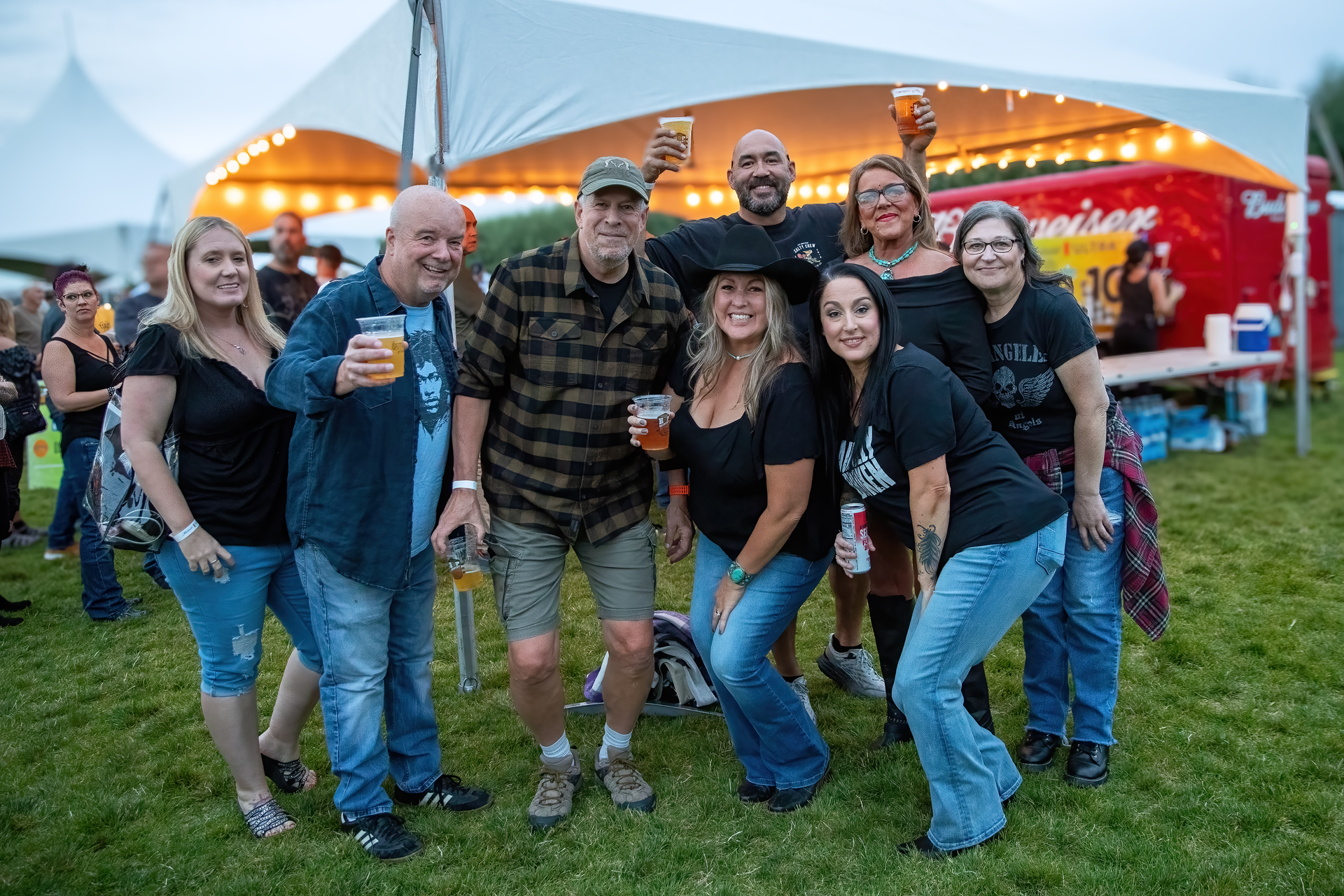 A group of people are posing for a picture in front of a tent.