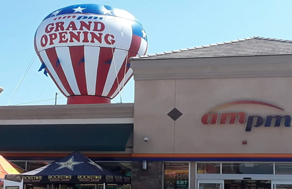 Grand opening balloon above ampm convenience store storefront