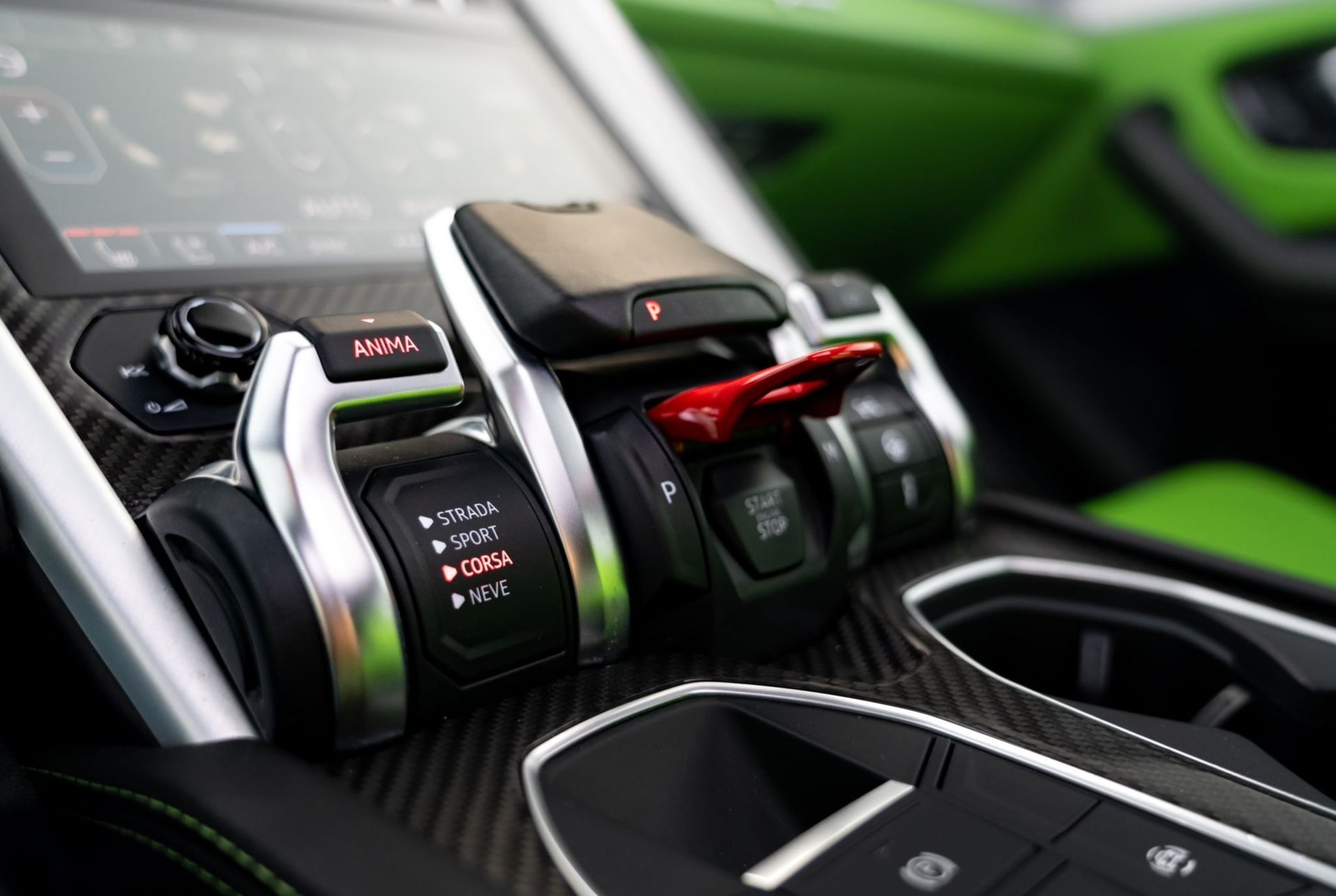 Close-up of a sporty car center console with drive mode switches and red accents