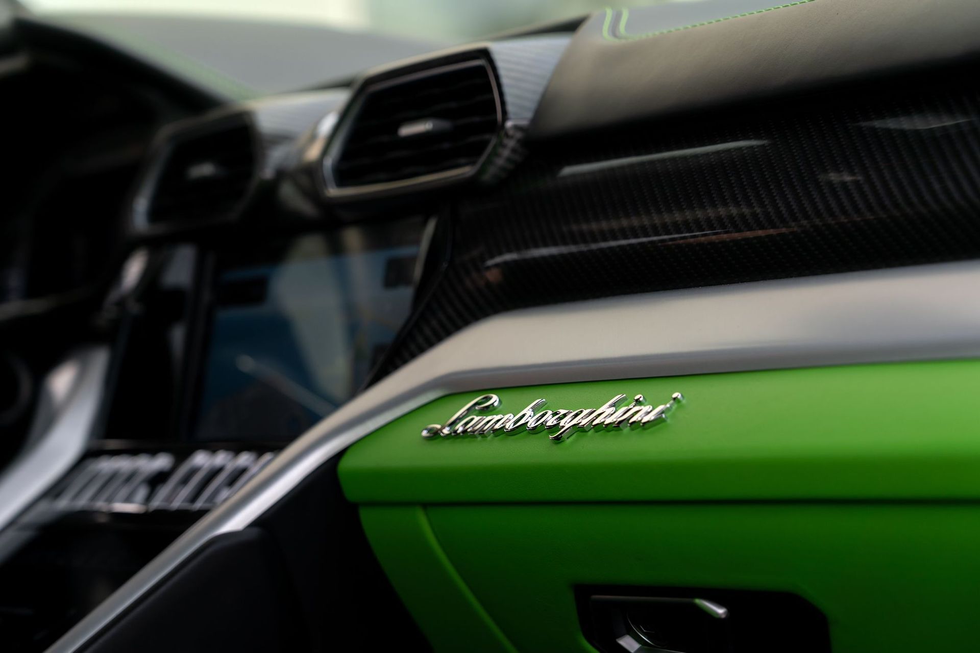 Close-up of a green Lamborghini dashboard and badge inside the car interior